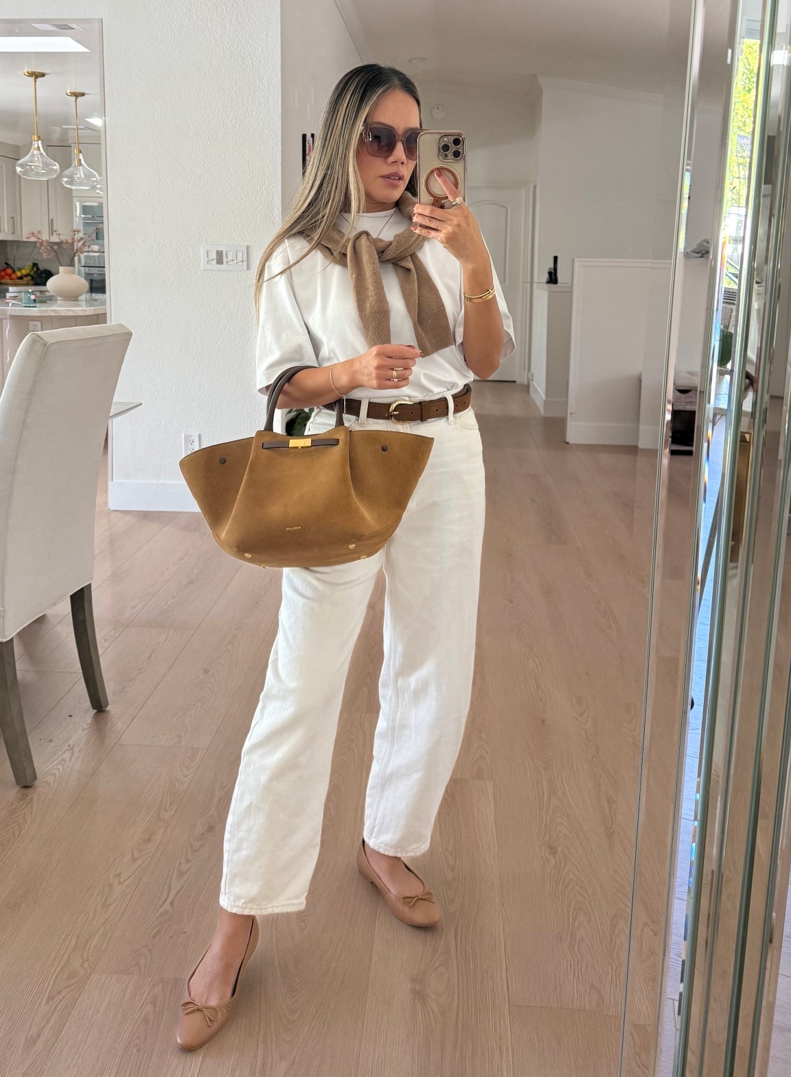 For a summer-to-fall transitional outfit, wear a white boxy t-shirt and white barrel jeans. Throw a cashmere cardigan over your shoulder for layering. Complete the look with brown accessories: a suede belt, a Demellier suede bag, brown ballet flats, and brown sunglasses. 

#LTKShoeCrush #LTKTall #LTKItBag