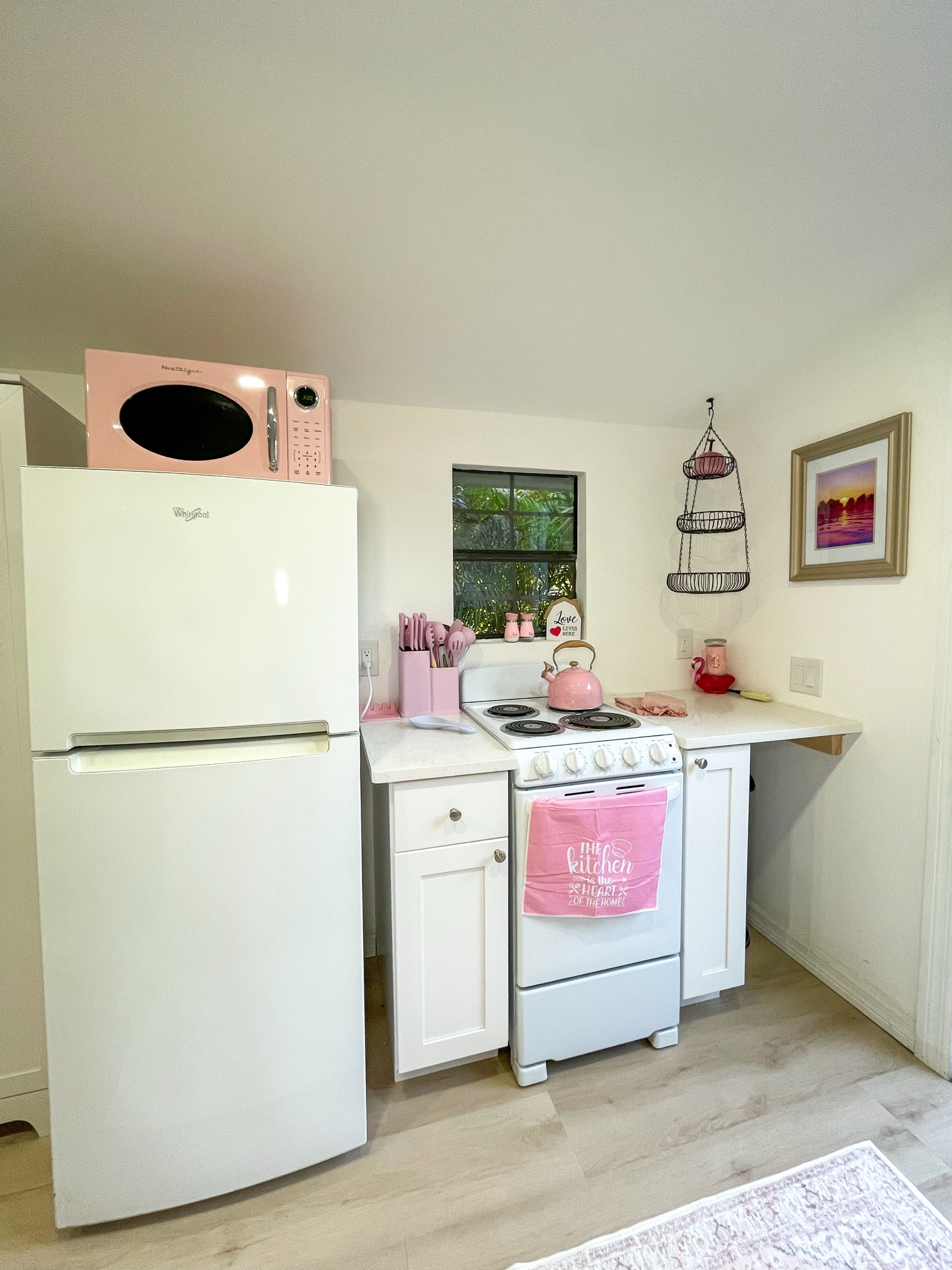 A fully equipped tiny home kitchen — pink touches included.