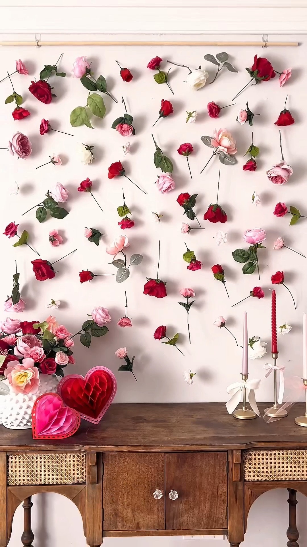 DIY Floating Flower Wall Hanging 🌹Save this pretty backdrop idea to make for Valentine’s Day! 

Here’s how:

❤️ Snip individual stems from faux flower bundles. ❤️ Arrange your flowers into rows first (optional, but it helps plan out colors + sizes!). ❤️ Hang a wooden dowel at the top of the wall (I used Command hooks). ❤️ Tie several lengths of clear string to the dowel at even intervals. Measure each strand to your desired length + a little extra for tying. ❤️ Tie flowers down each strand, alternating spacing and direction. Repeat across.
❤️ I let most of my flowers fall into place naturally, but if you want to secure them in a certain direction you can wrap the stem with a bit of floral tape. 

Galentine, diy party decor , galentines day party

#LTKHome #LTKValentine #LTKmomlife