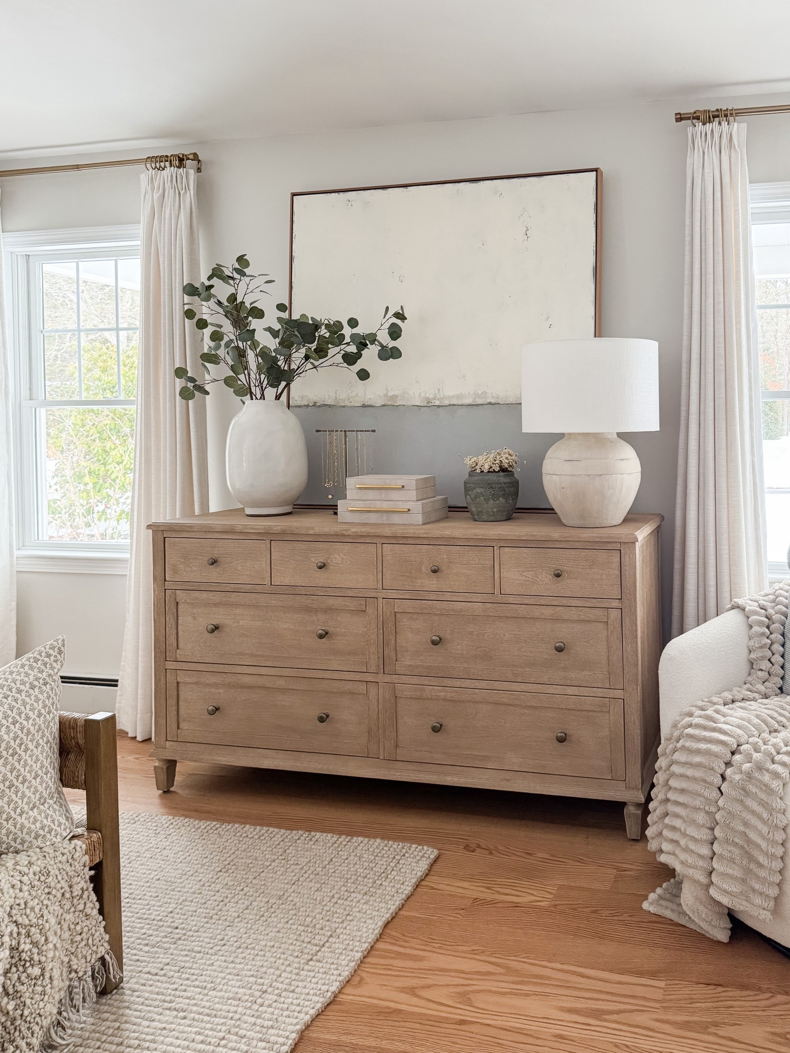Light wood dresser styled with oversized neutral artwork, ceramic table lamp, stacked decorative boxes, and greenery in a white vase. Balanced, minimal coastal styling for a serene bedroom. 
dresser decor, bedroom dresser styling, oversized wall art, neutral artwork, decorative boxes, ceramic lamp, greenery vase, coastal bedroom decor, light wood furniture, minimalist home decor, organic modern bedroom, styled surfaces, sherri calnan home

#LTKHome