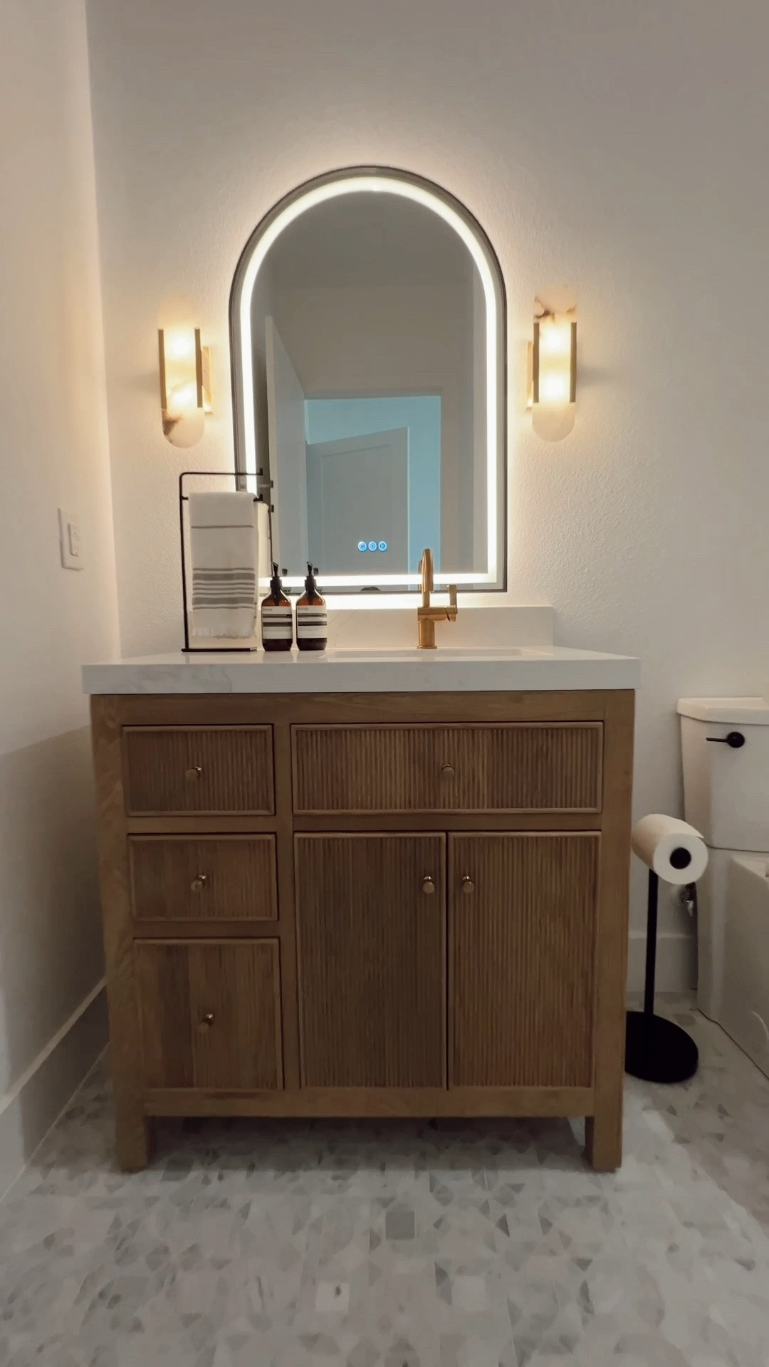 Luxury bathroom with a white oak fluted bathroom vanity, marble sconces and LED mirror. Love how there are grab bars to make it accessible and safe. Also linking my toilet lever, toilet paper stand black wastebasket  

#LTKhome