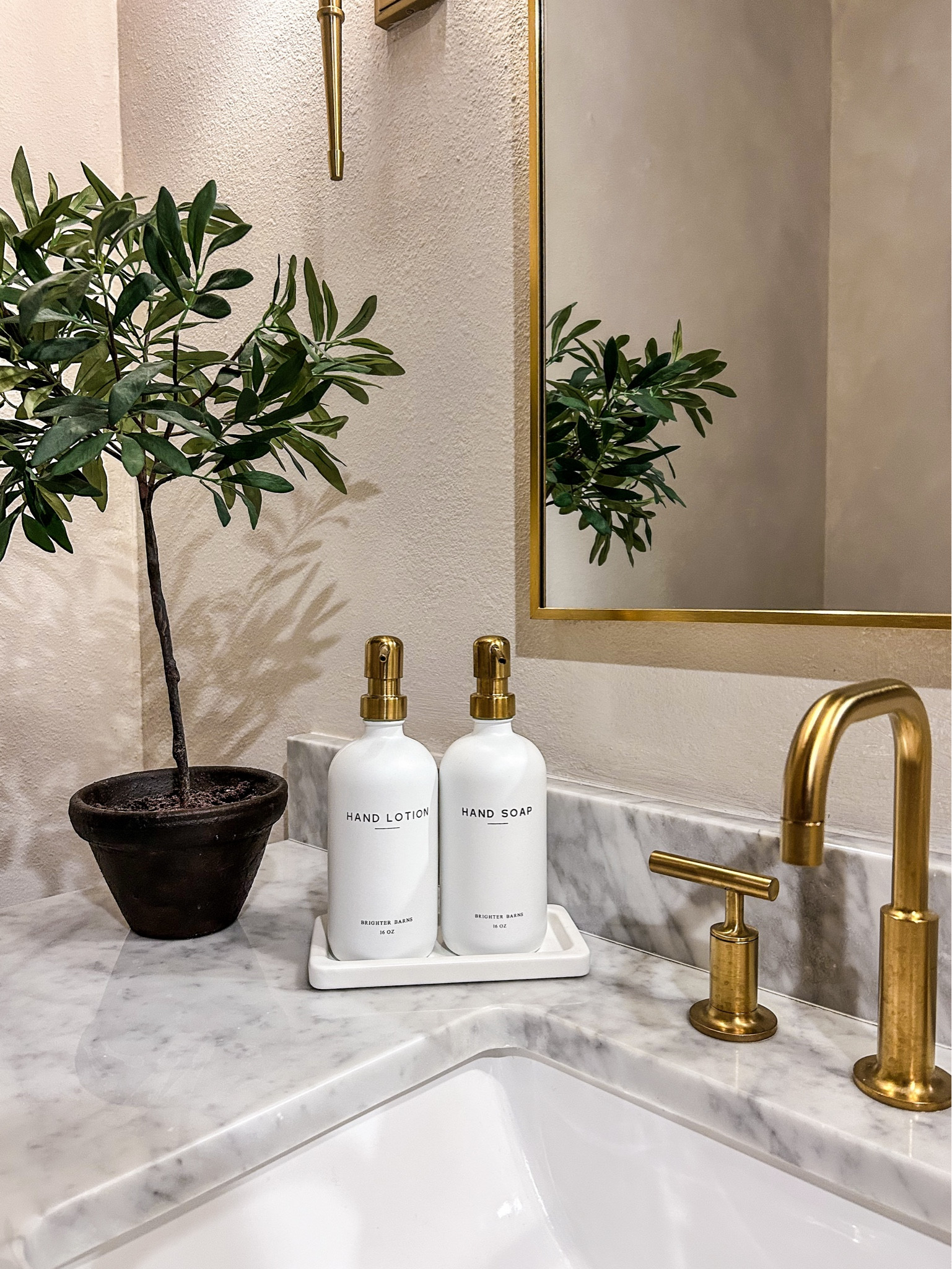 Elevated bathroom details that make a big difference. Marble countertops, brass fixtures, neutral soap dispensers, and simple greenery create a clean, modern, and timeless look.

#LTKHome #LTKSeasonal