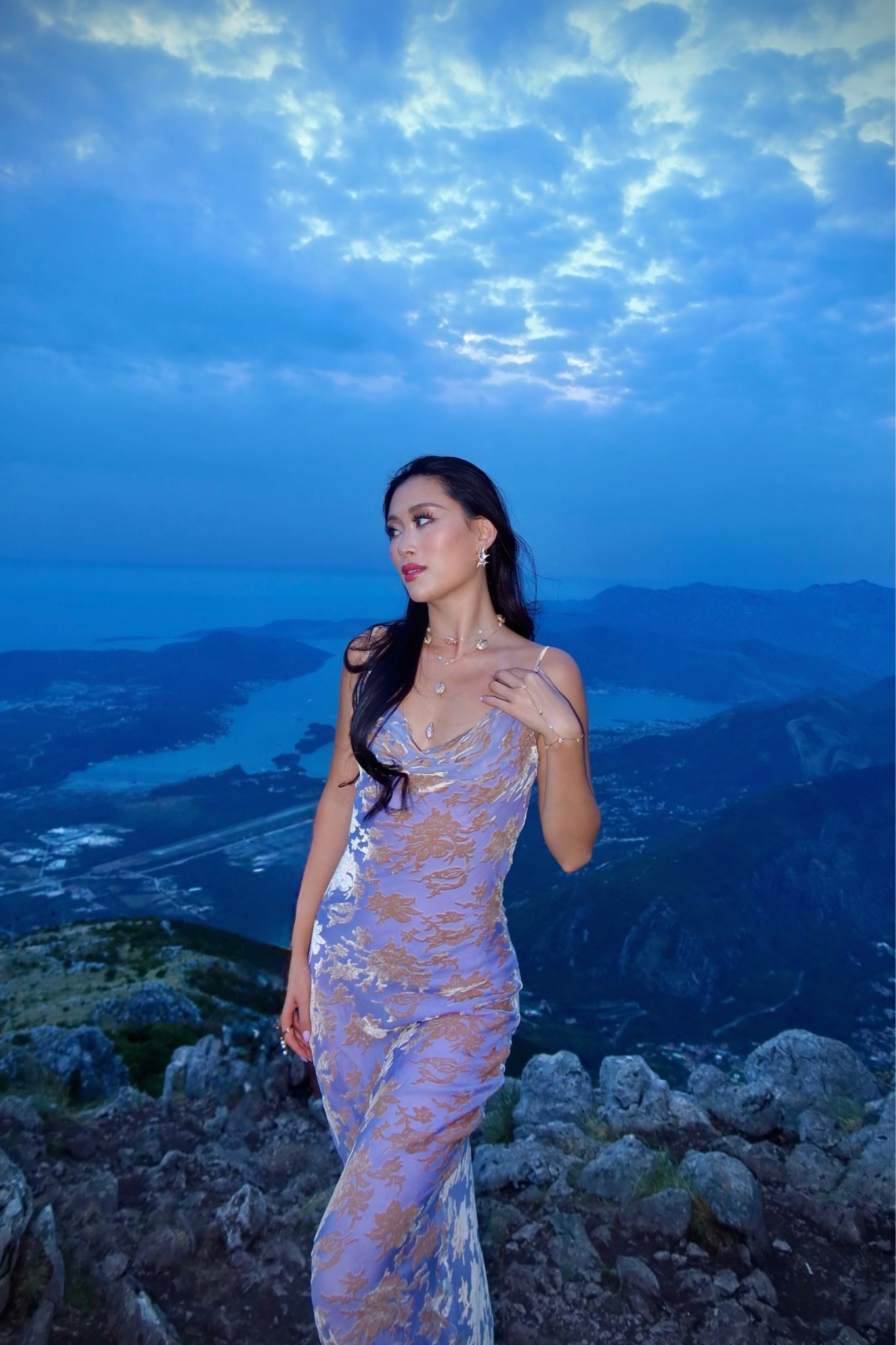a lavender and gold floral burnout velvet slip dress with a cowl neckline and a delicate gold body chain, styled with star drop earrings. the bias-cut velvet skims the body beautifully and the soft lavender-gold palette makes it an easy standout for dressy summer evenings. perfect for vacation dinners, golden hour photos, rehearsal dinners, and warm-weather formal occasions. shop this look linked above.