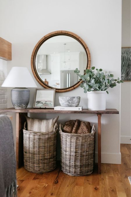In my living room I have styled this World Market console table with artwork, concrete bowl, faux greenery, table lamp, baskets filled with pillows and a throw blanket below and a round mirror above  

#LTKhome #LTKstyletip #LTKFind