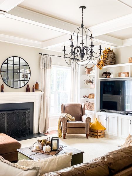 Make your neutral family room look cozy for fall with warm wood accents, cozy throws, dried gourds, and rich textured throw pillows. The large round window pane mirror looks great over a fireplace! The iron chandelier adds French country style. Drop cloth curtains keep things soft and neutral. The large bee skep adds texture and fun details. 



#LTKSeasonal #LTKhome