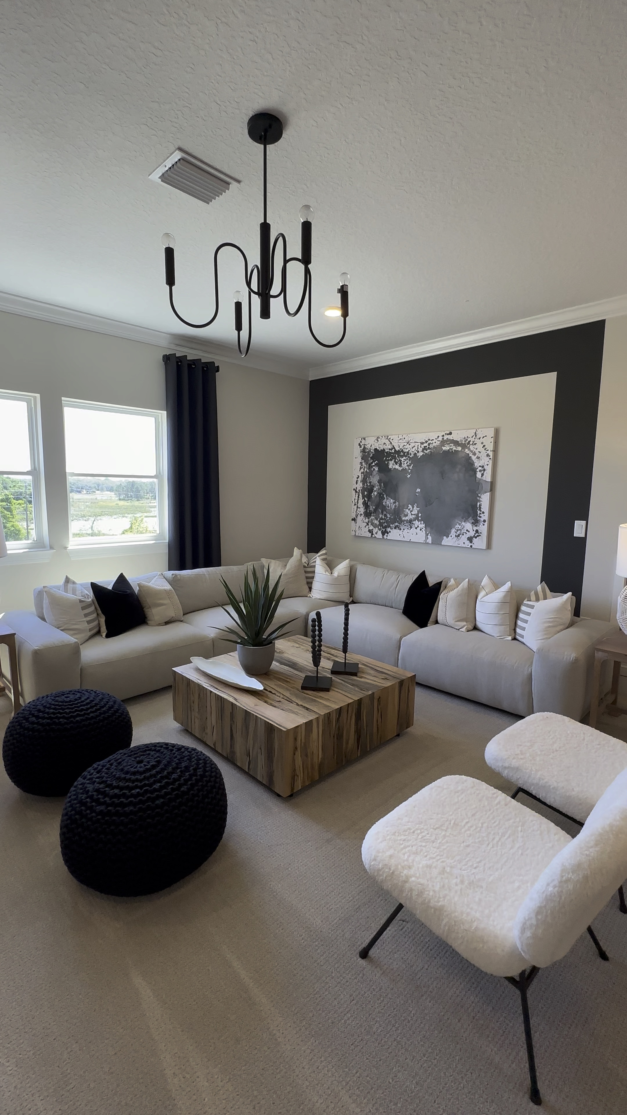 Black and White Living Room Decor with wood coffee table, modern art, black and white throw pillows and black poufs for additional seating 

#LTKhome #LTKVideo