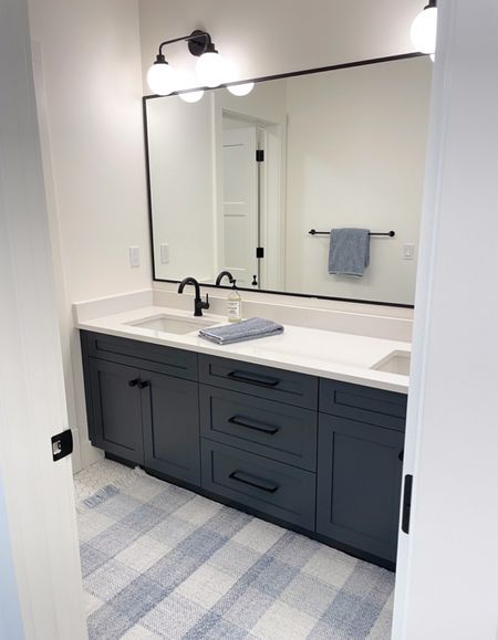 I had so much fun designing our guest bathroom, from the black double sconces to white hexagon floor tile, and everything in between. The style is a bit more youthful than our other bathrooms, with modern and vintage elements, including black high arc faucets, sleek pulls, dark navy vanity and more. The blue gingham rug and heathered towels from Serena and Lily cozy it up. Some items are currently on sale!

#LTKFind #LTKhome #LTKsalealert