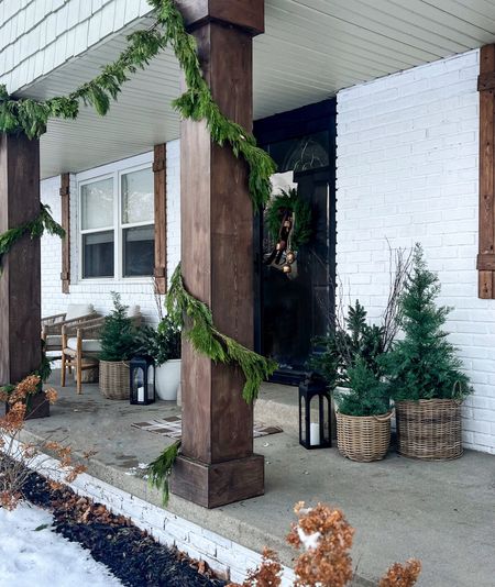 Christmas porch 
Love to mix fresh & faux to last through winter. fresh cedar wrapped columns & one planter with fresh bundles & twig branches for a rustic touch. Faux trees & wreath for winter. Simple and beautiful 

#LTKSeasonal #LTKhome #LTKHoliday