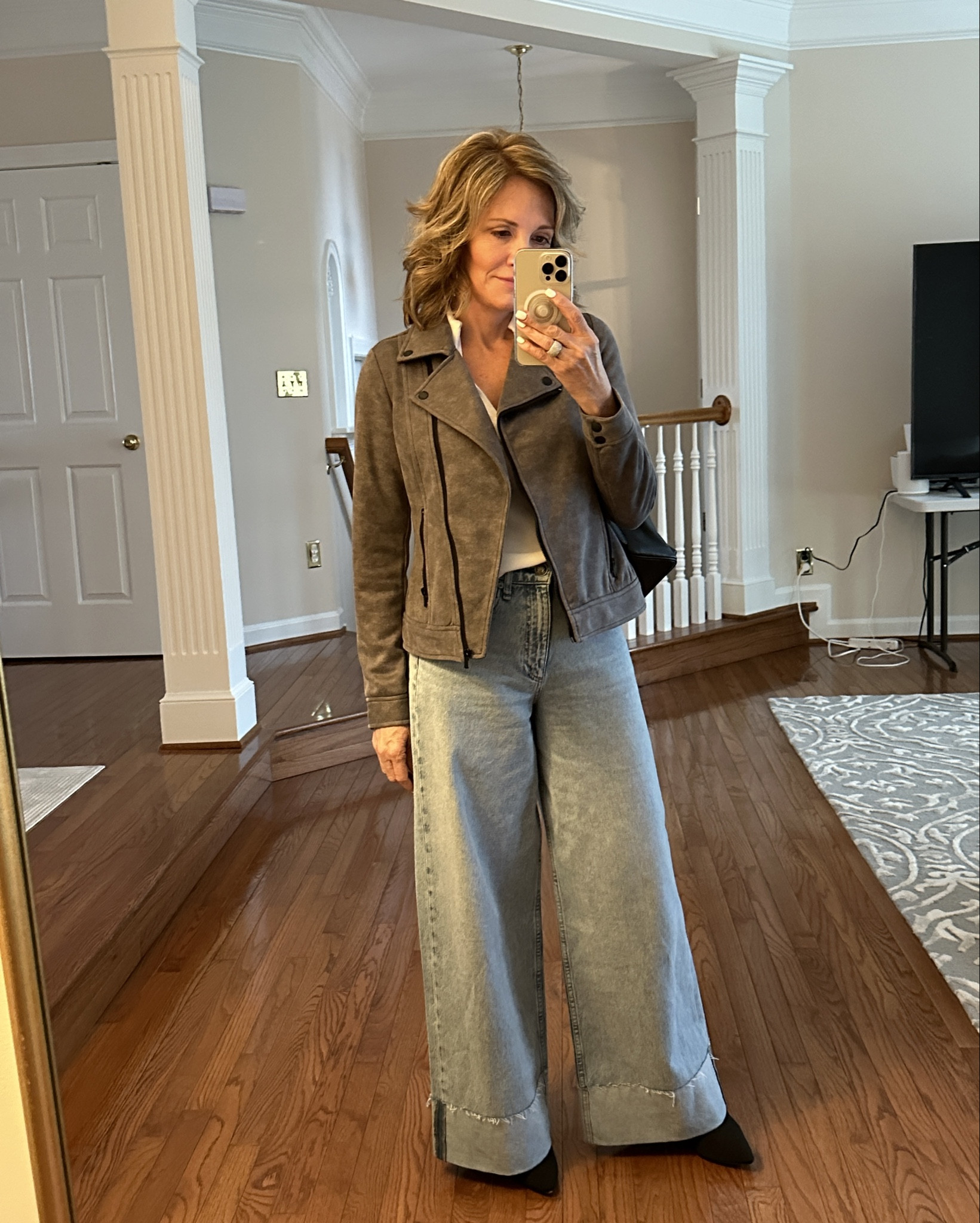 Wide leg cuffed jeans with moto jacket and mini backpack purse