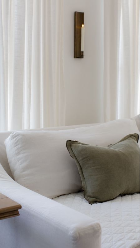 Slipcover sofa, white linen quilt, ivory curtains, brass wall sconce 

#LTKhome
