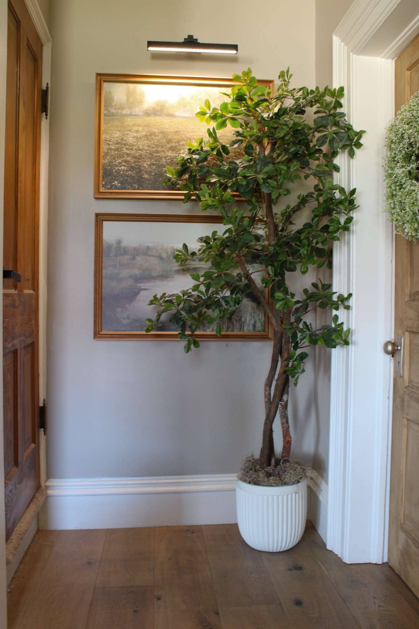 Every corner deserves to shine.

This neutral corner in my living room got a little extra attention this spring.

Simple styling featuring classic canvas framed landscape artwork from collection prints. (Custom graming from Michael’s Craft store) 

Accompanied by a minimal artificial black olive tree in a fluted neutral planter and topped off with modern, black picture light.

Everything feels a little more organic & lived in now.

The mix of warm wood tones, vintage-inspired frames, and soft greenery creates the perfect cozy cottage + modern farmhouse aesthetic.