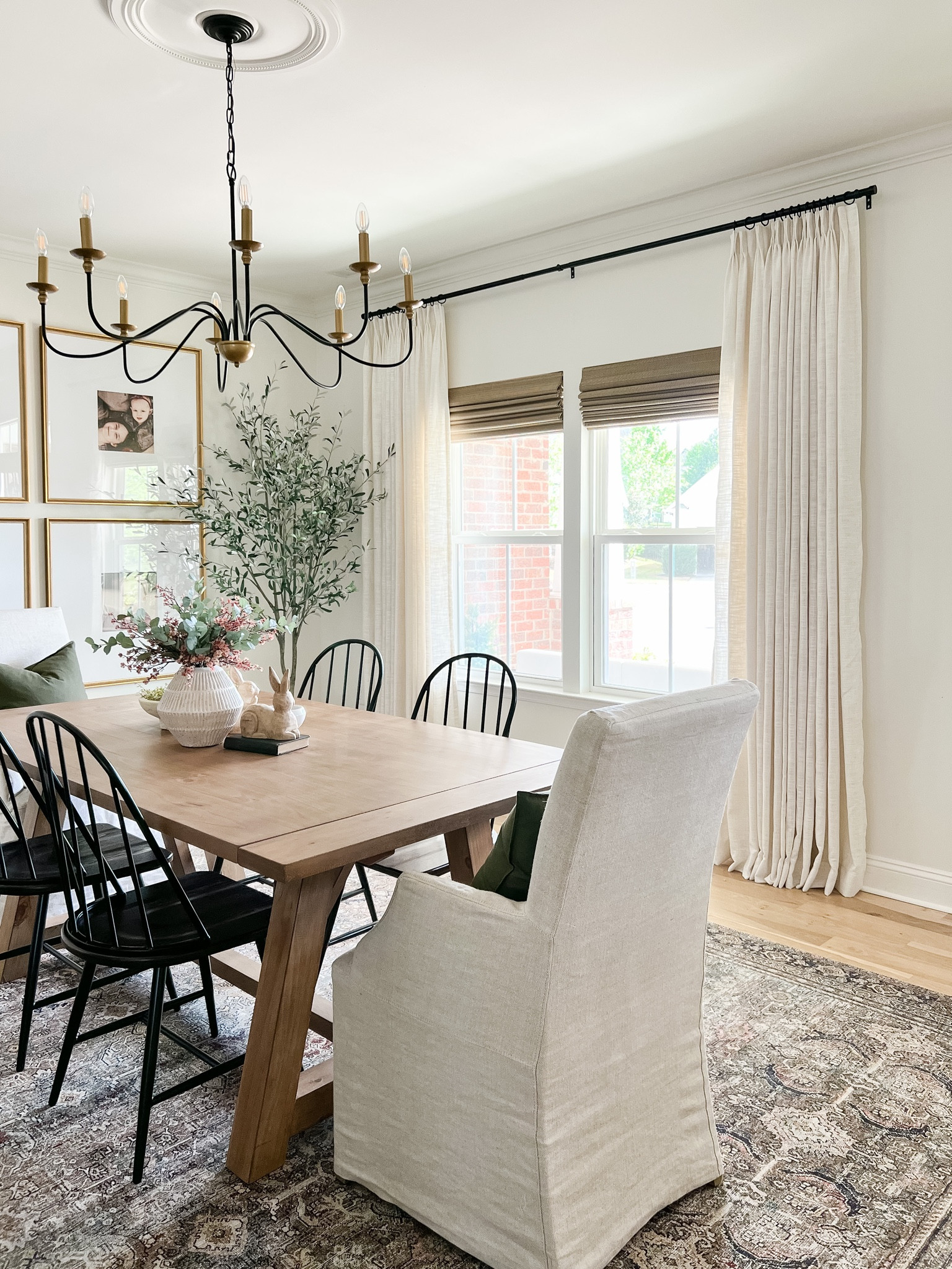 Dining room pinch pleat linen curtains, black curtain rod, Loloi Layla area rug, white oak farmhouse style table, spindle chairs, oversized gold frames, black and gold chandelier 

#LTKstyletip #LTKFind #LTKhome