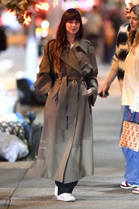 Shop Dakota Johnson's belted trenchcoat black Nappa lambkin chain embellished purse bag, white sneakers #DakotaJohnson #CelebrityStyle

#LTKWorkwear #LTKSaleAlert #LTKStyleTip