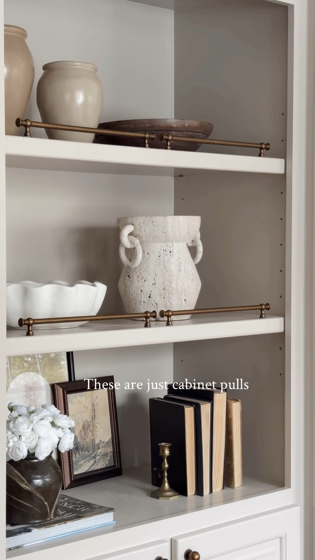 The most asked question I get is where I found my brass rails on
my bookshelf.

They are just good ol’ cabinet pulls. You can pick any size that fits your need. I attached them to my shelves with blue mounting putty and done! 

No drill necessary! 

That’s how I like to DIY