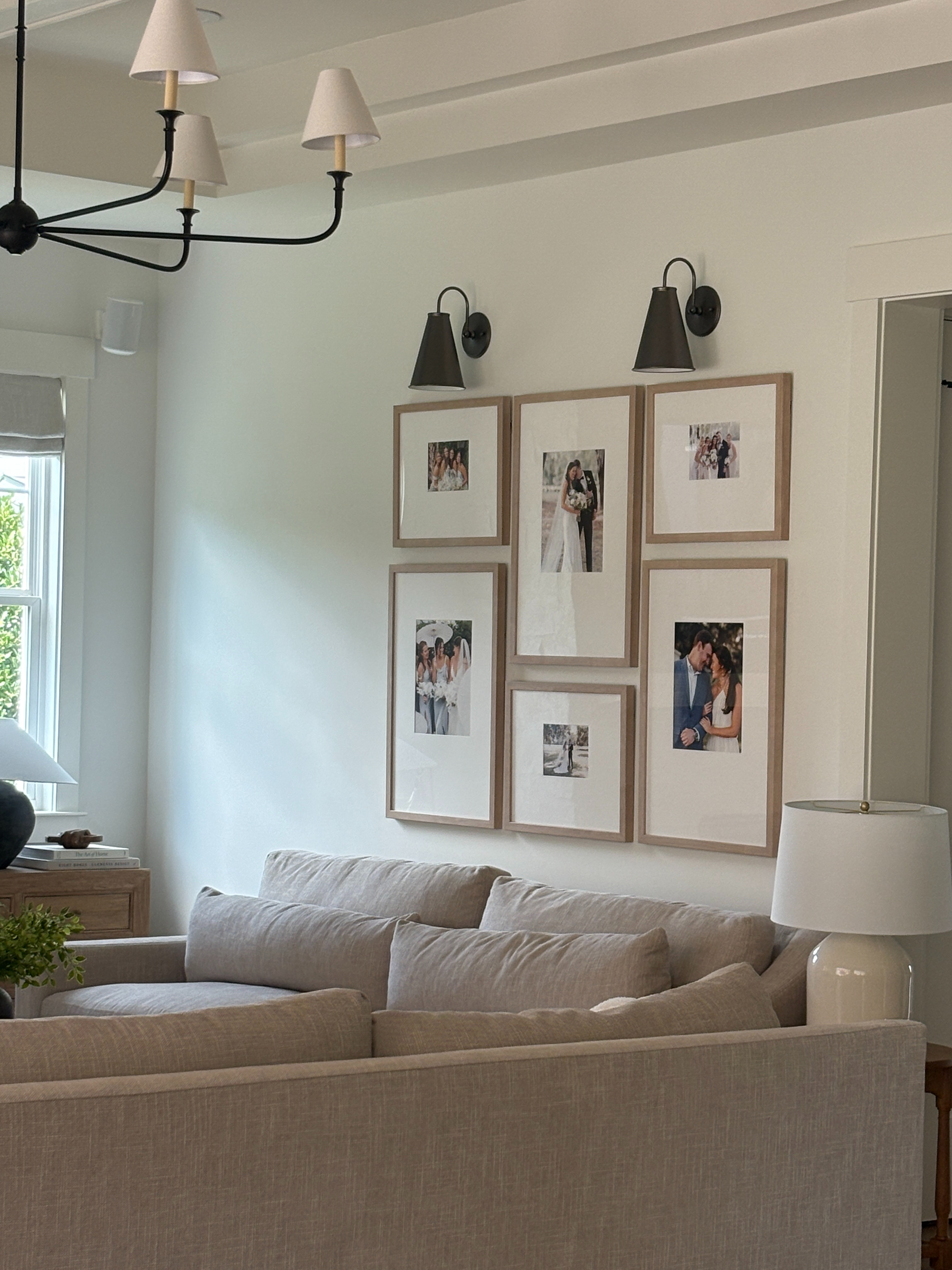 This neutral living room corner is the perfect blend of cozy and curated 🤍✨ The light oak gallery frames bring warmth against crisp white walls, while the black sconces and chandelier add the perfect modern contrast. A soft taupe sectional anchors the space — proving that minimal can still feel inviting and elevated.

🛋️ Shop the look:
▪️ Linen sectional sofa
▪️ Oak gallery frames
▪️ Black modern sconces
▪️ Neutral throw pillows
▪️ Soft white lamp base

#LTKhome #neutraldecor #livingroomdesign #moderntraditional #gallerywall #neutralhome #cozyinteriors #homeinspo #livingroomgoals #interiordesign #sofadecor #modernfarmhouse #LTKfinds 

 #LTKHome