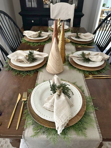 Festive neutral Christmas table inspiration with greenery, table top trees, linen napkins and gold flatware 

#LTKhome #LTKHoliday #LTKSeasonal