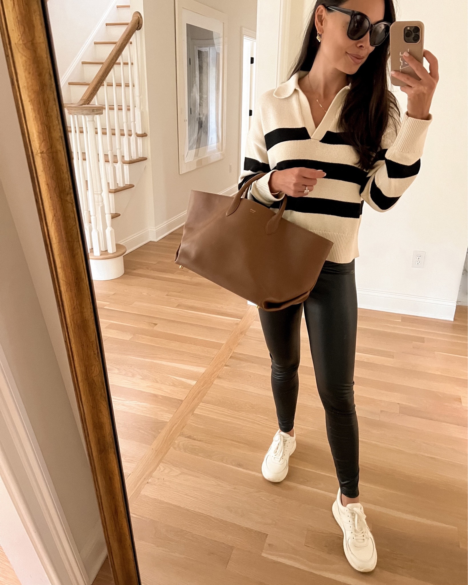 Kat Jamieson of With Love From Kat wears leather leggings, a stripe sweater and white sneakers with a tan Khaite bag to run errands. Classic style, neutral outfit, fall outfit.

#LTKstyletip #LTKitbag #LTKSeasonal