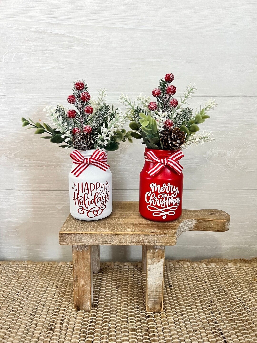 Add a festive touch to any nook with these charming mini farmhouse-style floral arrangements from PinkLizzyDesigns. Each petite piece features a painted glass vase—your choice of red or white—filled with a cheerful blend of faux eucalyptus and seasonal Christmas florals. Standing around 5” wide and 8” tall, they’re the perfect size for tiered trays, desks, shelves, or gift-giving. With customizable vinyl decal sayings and beautifully arranged blooms, these little accents bring cozy holiday cheer to every corner. #ChristmasDecor #FarmhouseStyle #MiniArrangements #HolidayHomeDecor #EtsyFinds #FestiveFlorals

#LTKGiftGuide #LTKHome #LTKHoliday