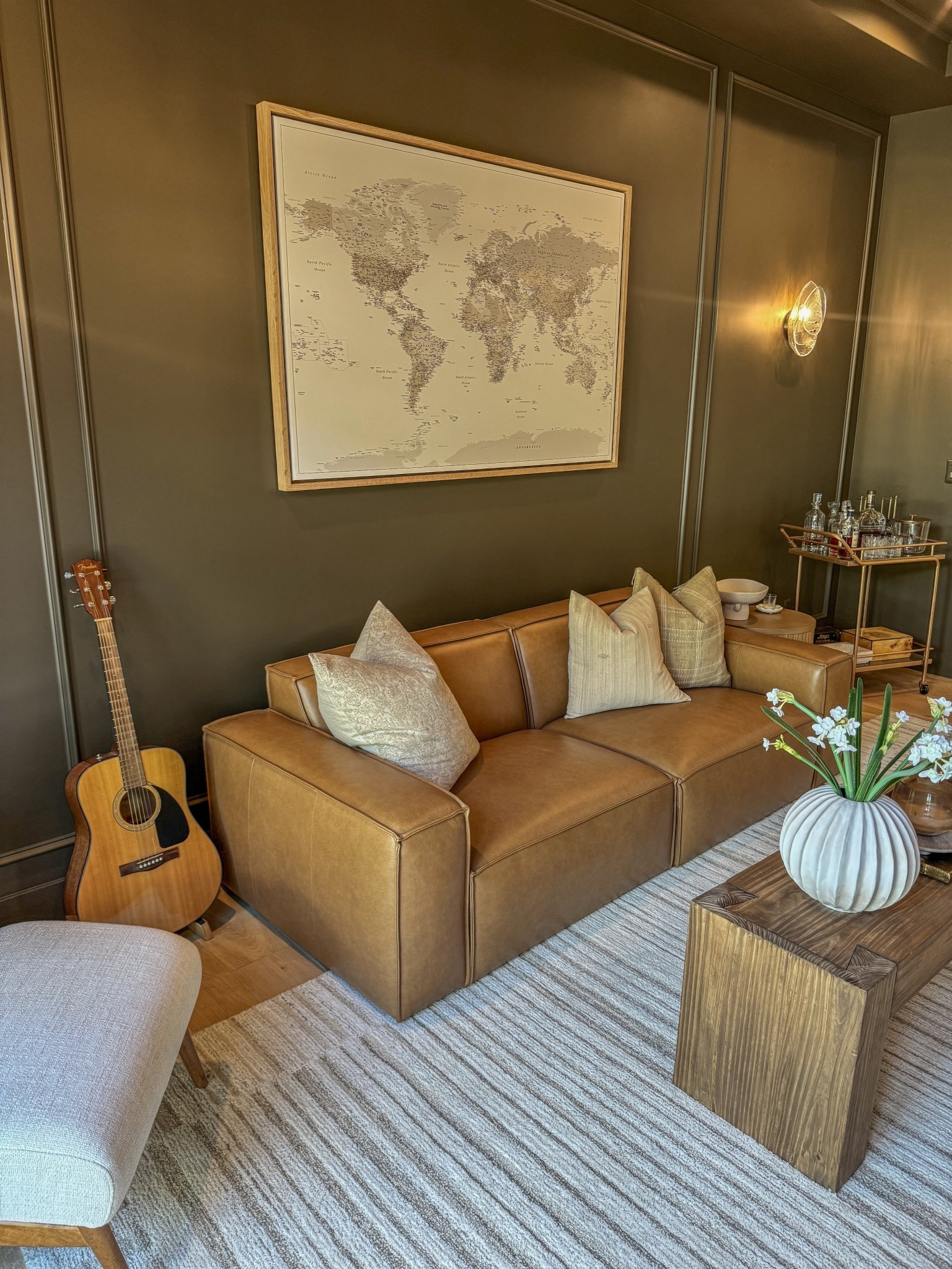 Our favorite hangout spot in our entire home🤍

Moody den design featuring a rich leather sofa paired with a rustic wood coffee table for a warm, grounded aesthetic. Dark, cozy den decor styled with layered textures, deep tones, and neutral accents that create an inviting and intimate atmosphere. Rustic modern den with a statement leather couch, handcrafted coffee table, and timeless brass hardware that adds warmth and subtle contrast. Neutral area rug anchoring the space while softening the darker elements and adding balance to the room. Moody home interior inspiration blending rustic materials, classic finishes, and modern styling for a sophisticated yet comfortable living space. Den decorating ideas that incorporate brass accents, warm wood tones, and tactile fabrics to enhance depth and visual interest. Cozy moody den perfect for relaxing, entertaining, or unwinding, designed with a refined palette of leather, wood, neutral textiles, and warm metallic details. Rustic modern den inspiration showcasing a timeless, layered look that feels masculine, cozy, and effortlessly elevated.

#LTKSeasonal #LTKHome