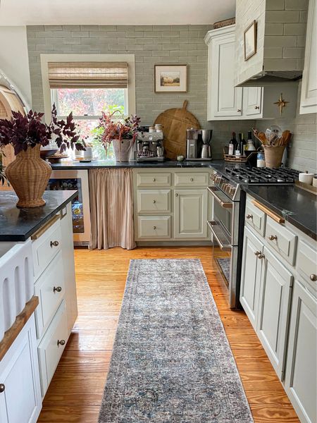 I know I shared a similar view Reel yesterday showing off the new  runner but thought I’d give a kitchen update today! 

01. All that’s left to paint is the island and a few side panels…a long process for a variety of reasons but I LOVE the tonal color with the @fireclaytile handmade brick. 
02. The @linagordievskyart piece found a home in a thrifted frame with linen mat and it’s perfect on that wall. 
03. I’m thinking of swapping out the striped curtain for a floral block print to add a little more visual interest. 
04. Zoom in to see the vintage candle sconce I added under the vent hood (its mate isn’t visible here).
05. Still contemplating new island pendants…perhaps with some brass. 
06. Planning to add the same decorative metal screen that’s on our built-in to the door of the drink fridge! 
07. While I’ve loved the idea of the arched cabinet we use as a pantry, it’s not quite big enough nor is it tall enough. The plan is to get something made to go floor to ceiling & butt up right to the tile edge. 

Finally, I considered filling & drilling some holes to use pulls on some drawers. I don’t necessarily love that every single cabinet & drawer has a knob only but I’m embracing them at this point. When the time comes to renovate the kitchen, I’ll get the cabinets & hardware I want….

Phew! Can’t wait to finish up and share the “new” kitchen soon! How do you think it’s all looking?! 

#farmhousedialfano #kitchendesign #tiledesign #cottagecore #cottagekitchen #cljsquad #bricktile #adstyle #postitfortheaesthetic #oldhouselove #inmydomaine #houseandgardenuk 

#LTKSeasonal #LTKstyletip #LTKhome