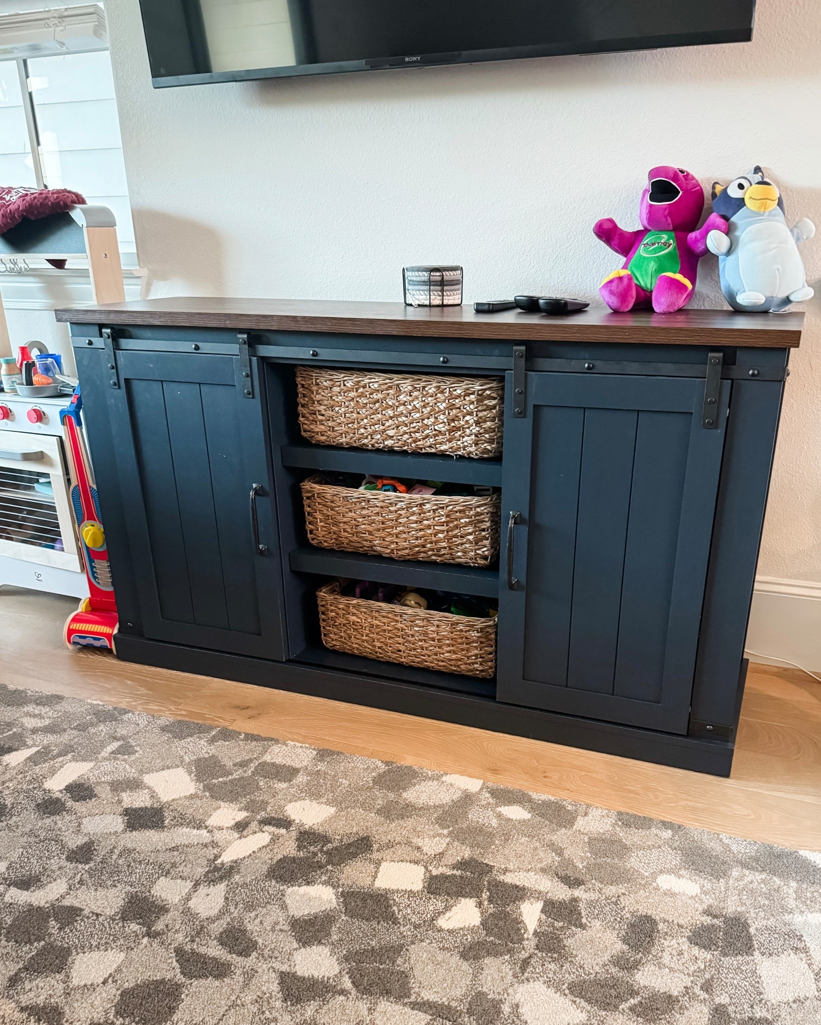 Living room toy storage that actually works for real life. I styled our navy blue TV stand with woven basket bins to keep my son’s toys organized and out of sight. Since our living room doubles as a playroom, I love finding functional storage that still feels elevated and clutter-free. Extra toys are tucked away behind the cabinet doors for a clean, minimal look.

#LTKmomlife #LTKHome #LTKKids