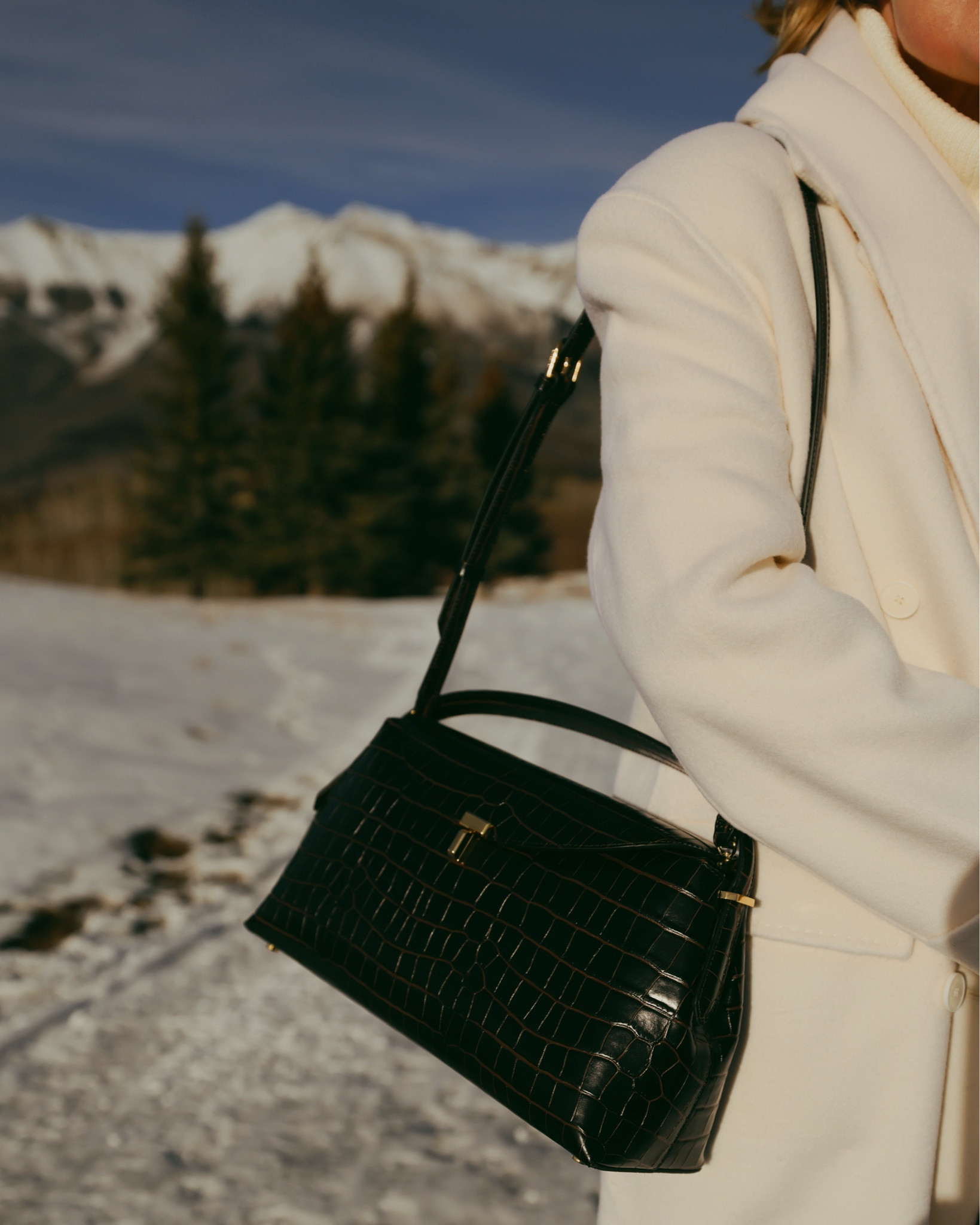 Your bag is often just a grab-and-go piece as you head out the door. But it’s an important detail that really can make the look. The right handbag adds structure, texture, and that final layer of polish that pulls everything together.

This gorgeous Toteme T-Lock bag  combines two major winter trends—deep chocolate tones and croc embossing—but in a way that still feels timeless and refined. The silhouette is structured, the hardware is minimal and elegant, and it’s surprisingly roomy. You can carry it on your shoulder or by the top handle, depending on your preference.

Think of your handbag as the final touch that truly completes the outfit.