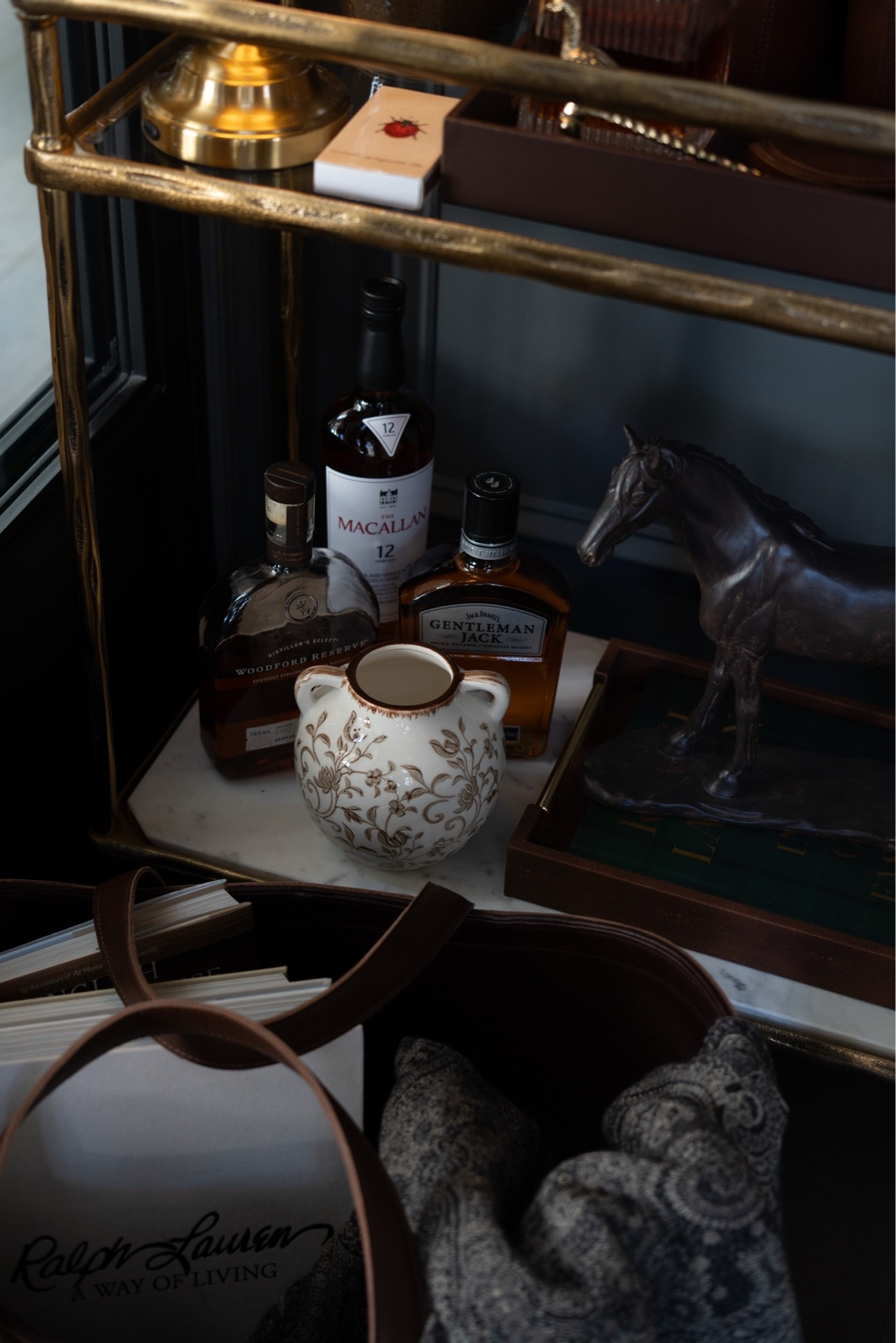Guys, I just redid my bar cart with the modern heritage aesthetic and I'm absolutely LOVING it! A brass bar cart, leather wine bucket and cocktail shaker, a crystal decanter, cut crystal glasses, and a cordless brass lamp with a pleated shade. Add faux oak leaf stems with acorns and a glowing candle, and it's pure cozy fall bar cart styling. 🍂🥃

#barcart #barcartstyling #falldecor #modernheritage #falldecorideas #homebar #cozyhome
