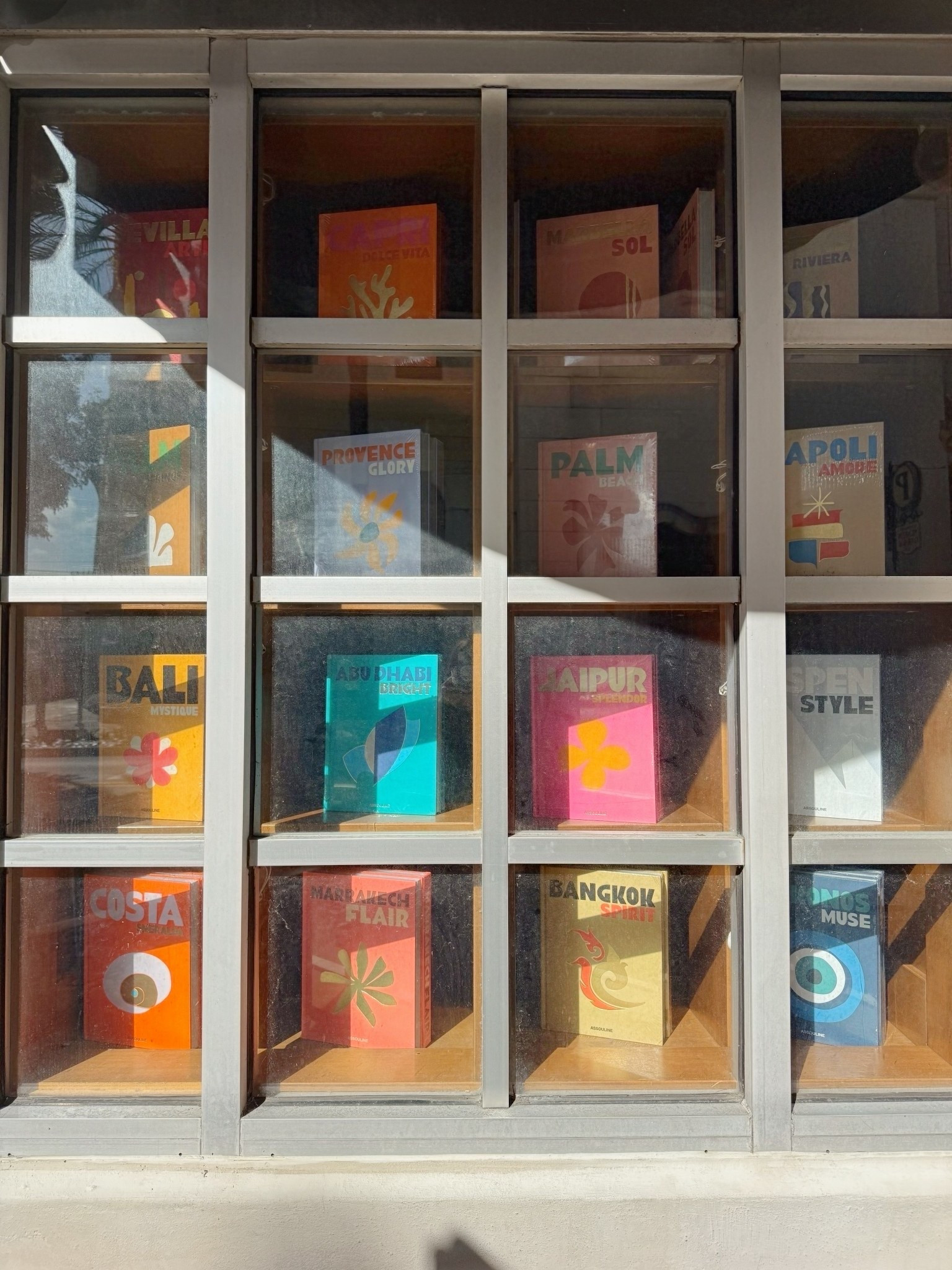 Window full of Assouline classic travel series oversized coffee table books. Pops of color for your living room side or coffee table. 

#LTKOver40 #LTKHome #LTKstorytime