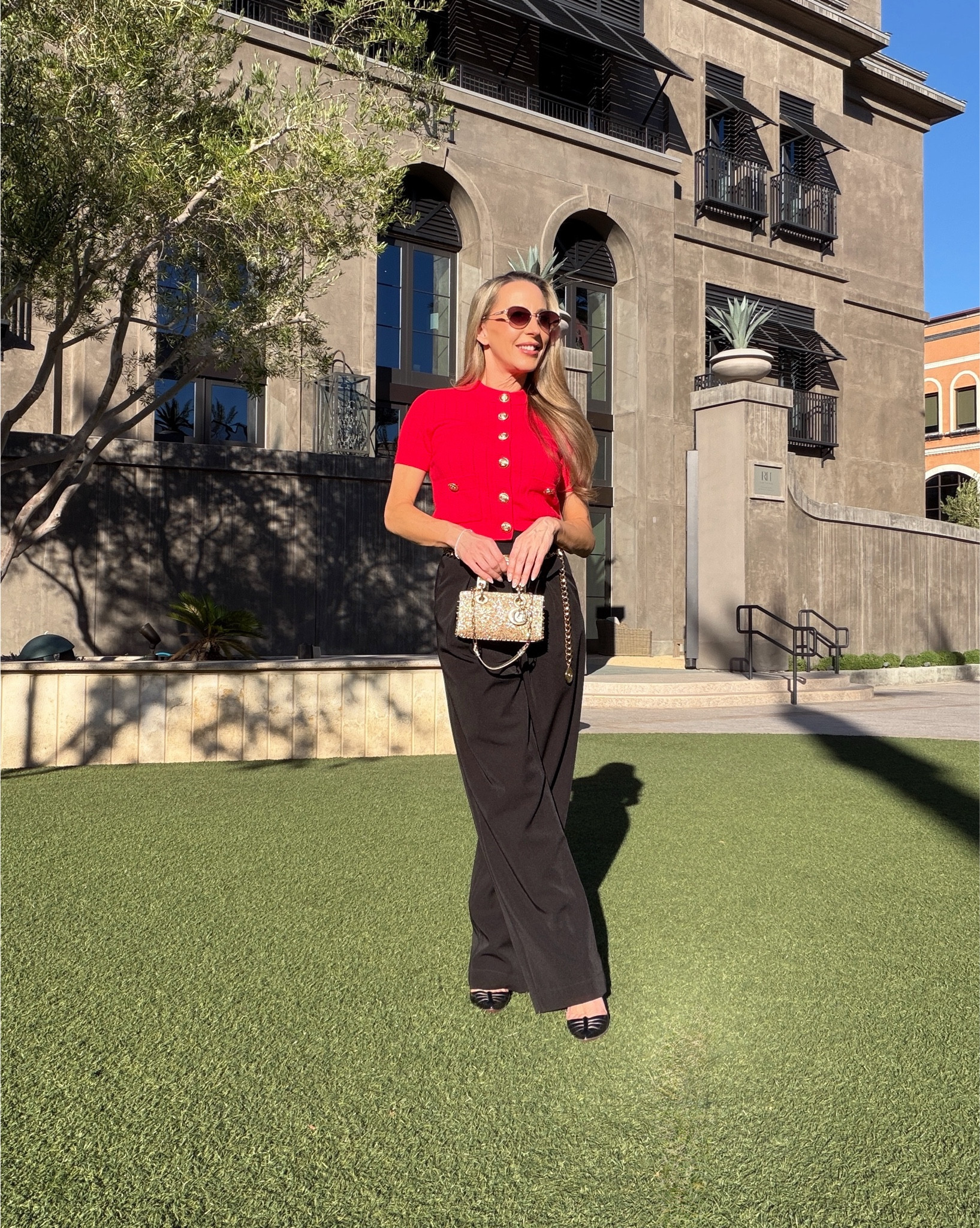 OOTD Fall outfit inspo: black high waisted pants, Chanel gold chain belt, red cap sleeve cardigan with gold buttons, black stiletto heel Christian Louboutin heels, Quay oval sunglasses from their limited-edition holiday collection (crafted with delicate metal work & embellished pearly details) & a gold crystal embellished Lady D-Joy bag. 

#LTKSeasonal #LTKStyleTip #LTKItBag