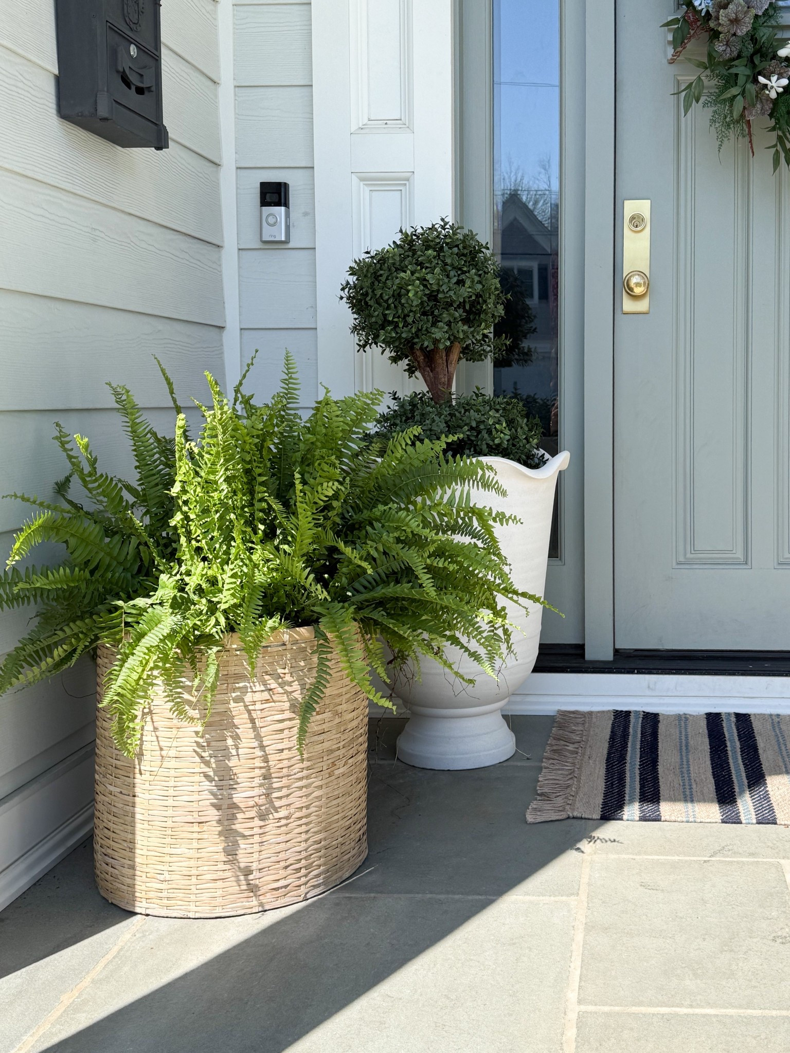 I love how this pairing of planters brings in so much texture and contrast without feeling overdone. The woven basket adds that relaxed, natural feel while the sandstone planter keeps things polished, and the mix of full ferns with structured topiary makes everything feel balanced and layered. Such an easy way to elevate a front entry with just a few well chosen pieces.

outdoor planter styling, front porch planters, woven planter basket, classic urn planter, fern planter ideas, topiary front porch, layered outdoor decor, entryway curb appeal, neutral exterior styling, outdoor greenery ideas, front door decor girlonthehudson

#LTKSeasonal #LTKHome