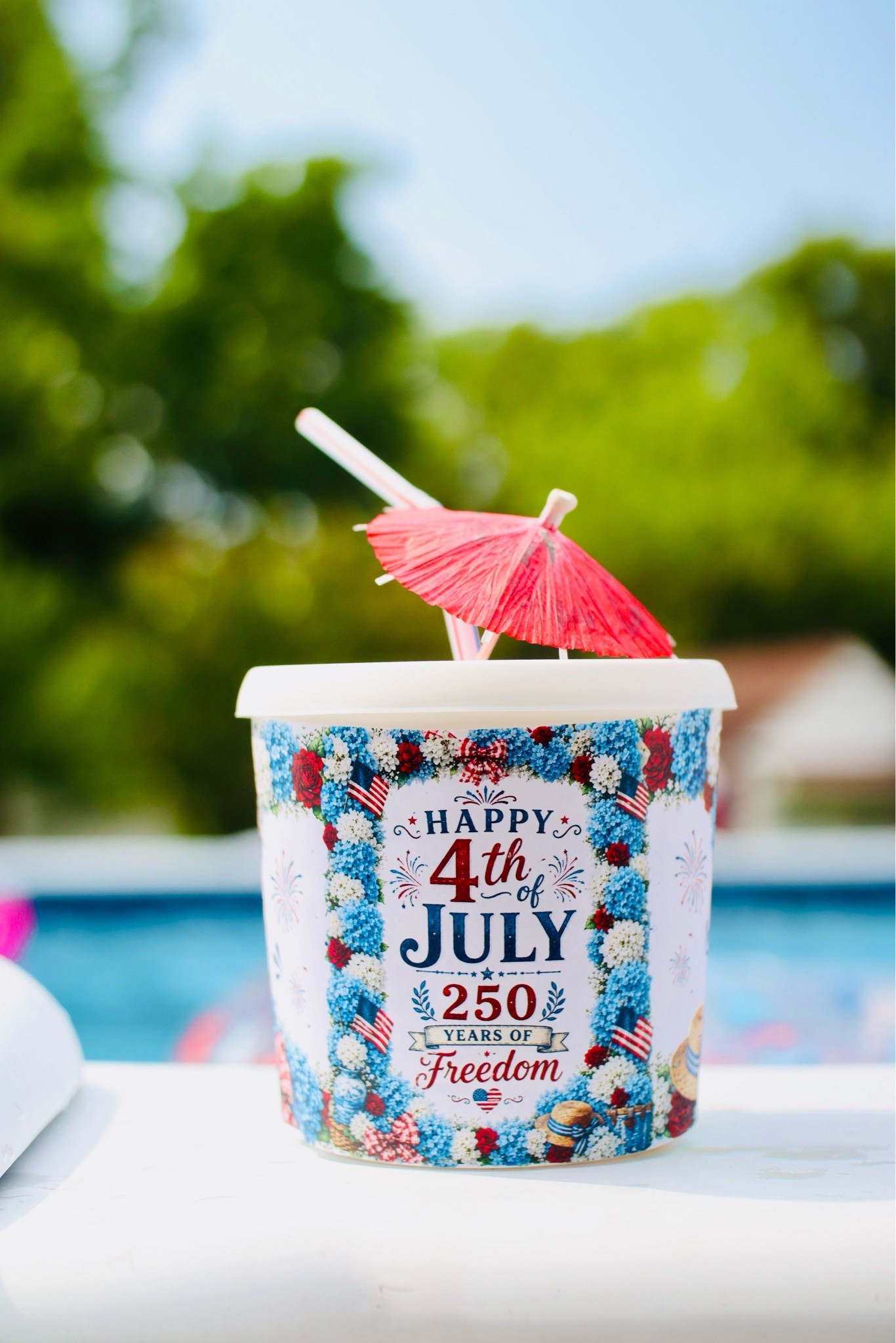 Story time I had on my list that I wanted to order drink buckets for our Fourth of July patriotic pool party and waited till the last minute when unfortunately they weren’t going to arrive in time. Ironically, we had been saving yogurt, containers and lids for crafts for the kids or water for paintbrushes things like that, and an idea just popped in my head that I would wrap the lid and the yogurt container. Use an X-Acto knife to cut out the hole at a straw and a fun umbrella and those were our drink buckets for our pool party.