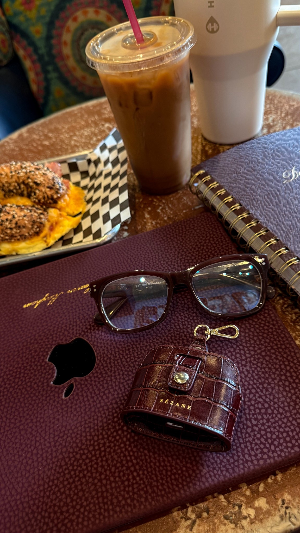 out of office… kinda. my essentials for working from a coffee shop! 

blue light glasses, laptop case, airpods case, planner, water bottle 