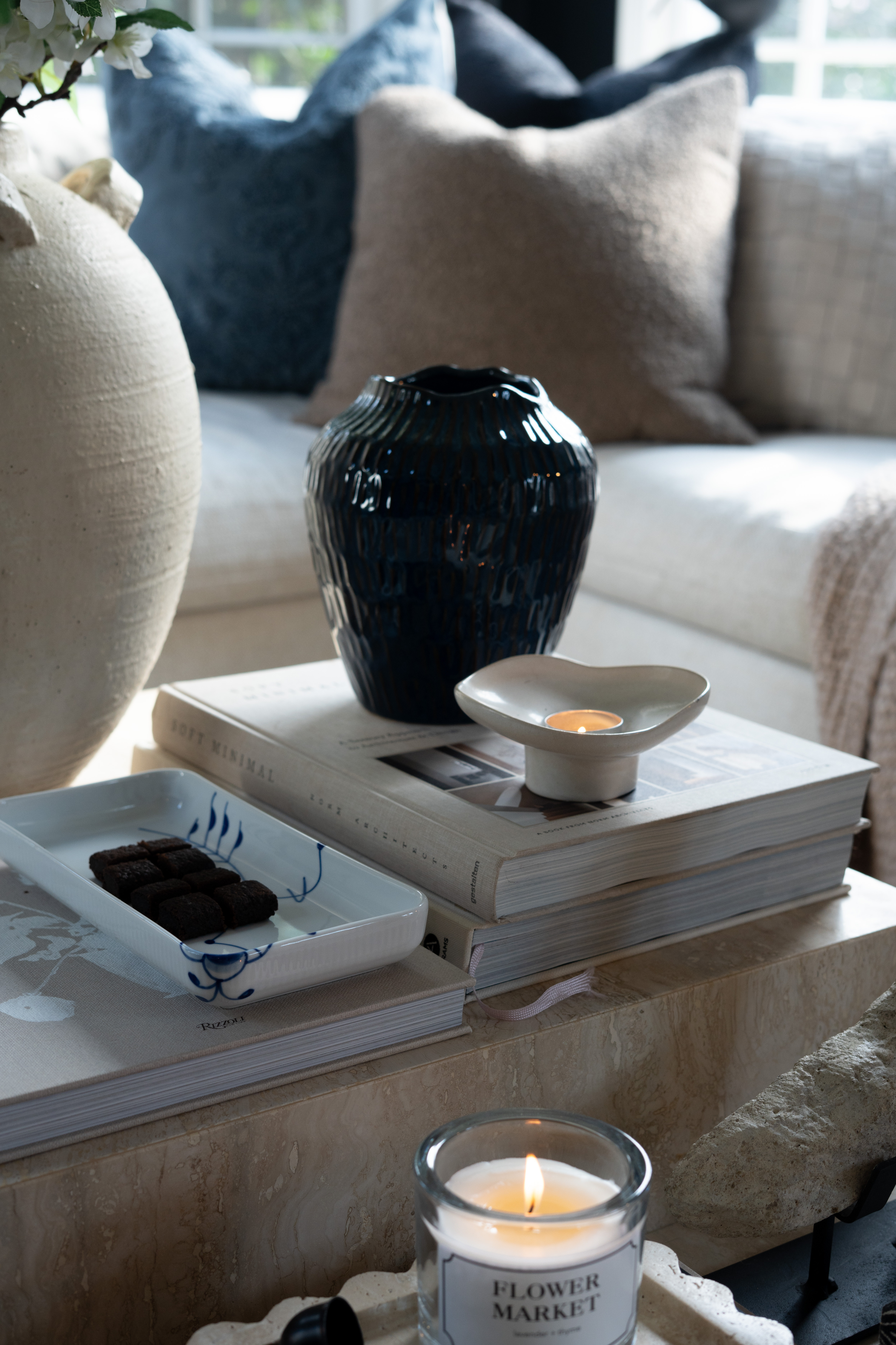 It’s the little coffee table moments like this that make a room feel so cozy. The stacked design books, soft candle glow, marble table styling, and layered neutral textures create the most calm and inviting living room vibe. I love how the subtle blue accents and simple decor pieces bring everything together in such an effortless way. 

 #LTKSpringSale #LTKSeasonal #LTKHome