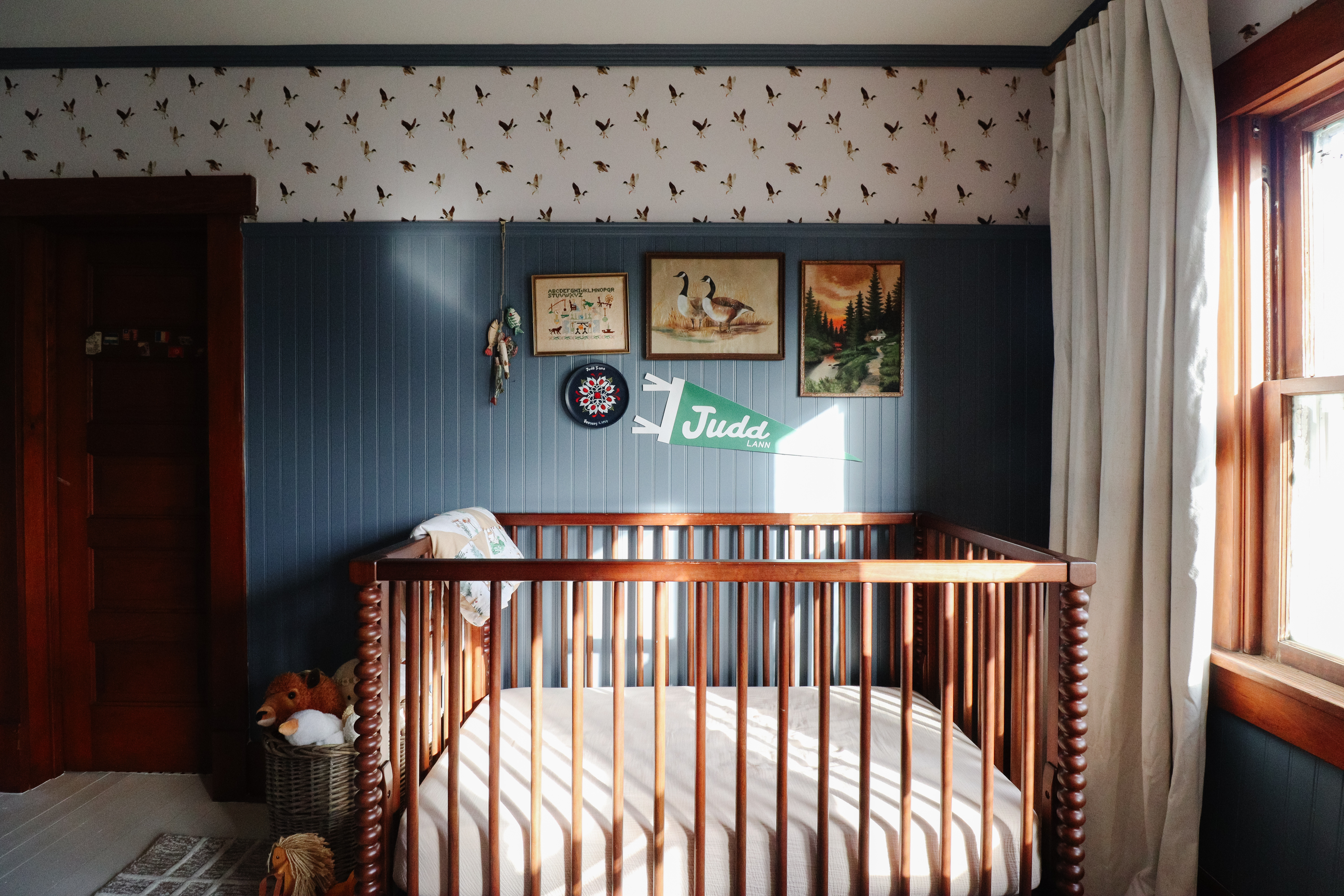Judd’s side of the shared room — cozy & vintage. The blue paneling, mallard wallpaper, and little crib corner make this space feel so sweet for him. 

 #LTKHome #LTKKids