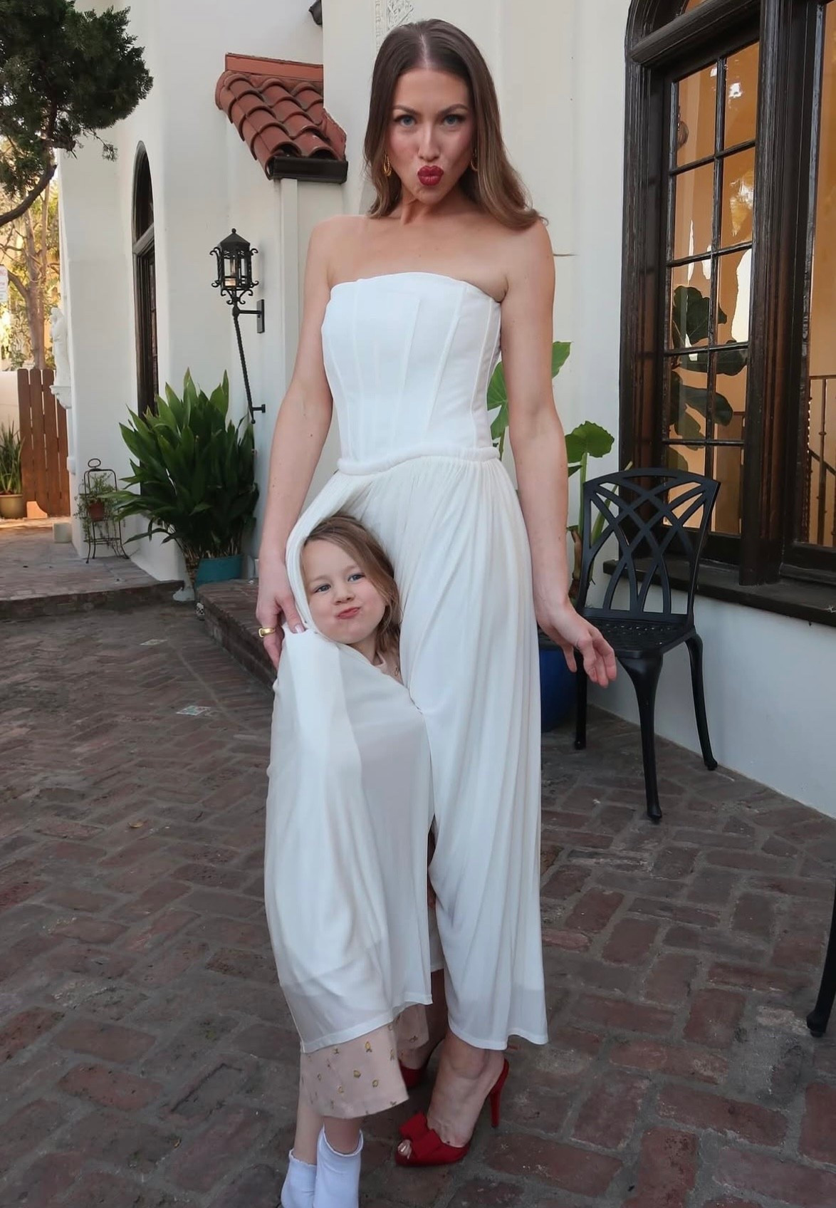 Stassi Schroeder's white midi-dress features a strapless bustier bodice and a romantic draped skirt.