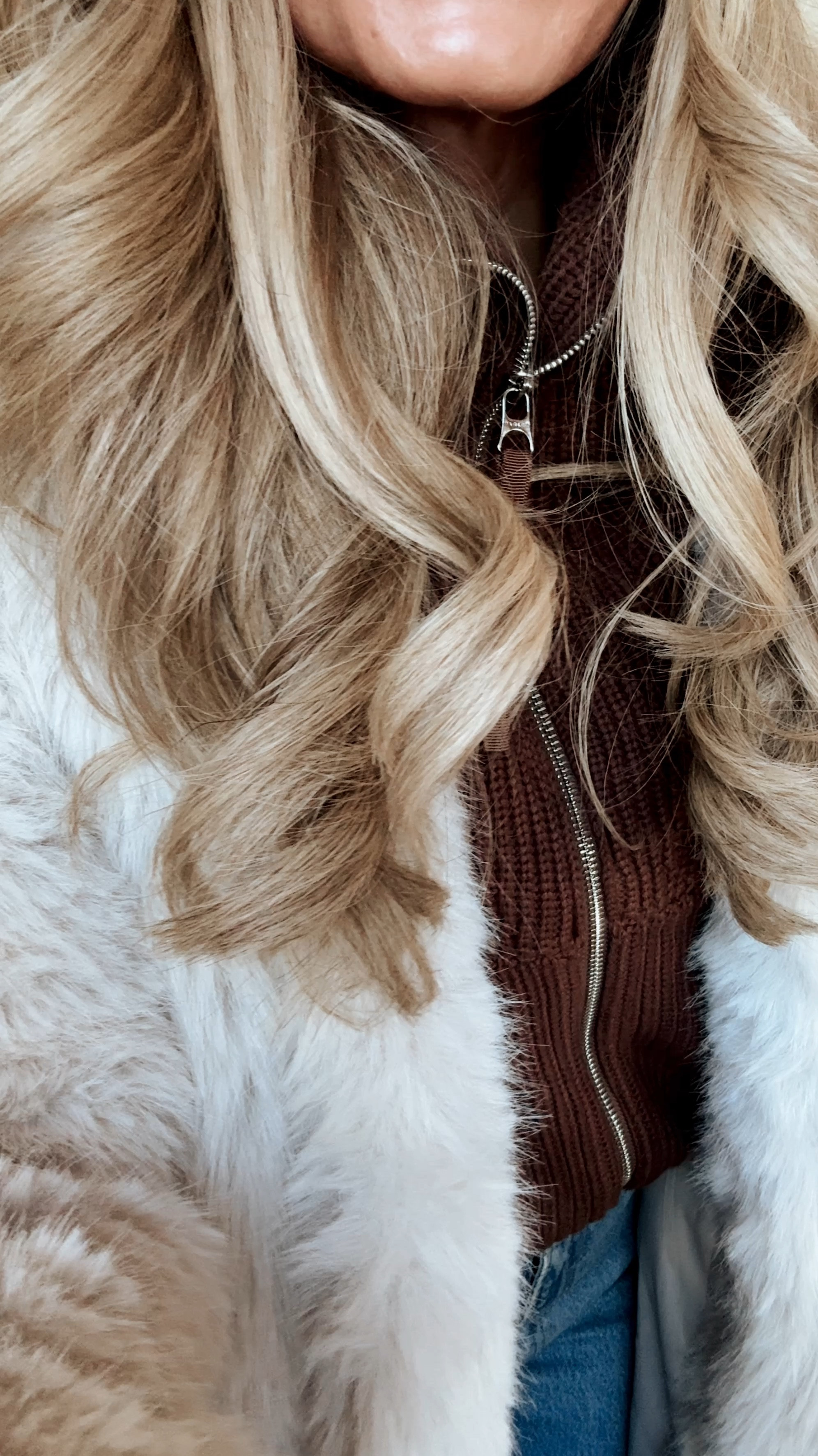 Winter snow outfit wearing faux fur tan coat with Varley zip up and Abercrombie jeans 