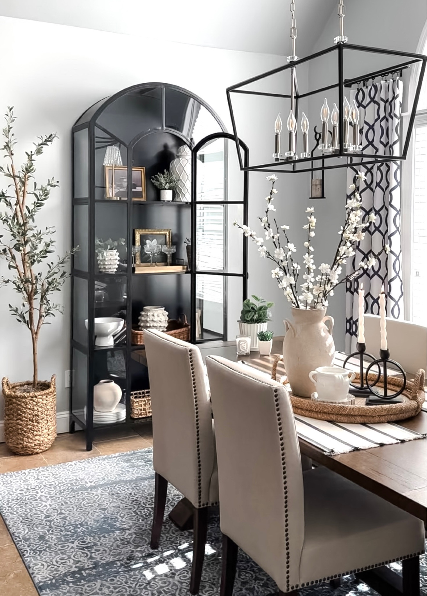 Spring dining space! Shop black display cabinet, olive tree, spring blossom stems, tray, candleholders, textured, rustic vases, fragrant candle, twist candles, wood table, upholstered dining chairs, area rug. 

#LTKsalealert #LTKhome #LTKfindsunder50