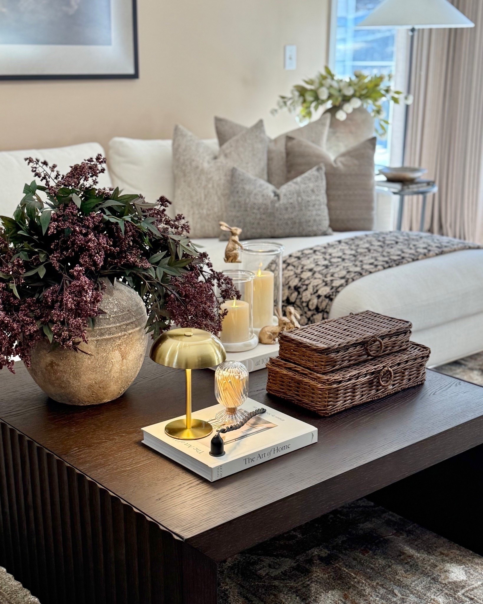 Neutral Living Room Coffee Table Styling with Wicker Boxes & Brass Lamp

Follow @farmtotablecreations on Instagram for more home styling ideas and daily deals.

A layered coffee table moment that feels warm, relaxed, and pulled together. The wicker storage boxes add beautiful texture while also being practical for hiding remotes or small items. Paired with a soft brass lamp, a stack of coffee table books, and a statement vase filled with rich stems, the whole look feels cozy and elevated without feeling overdone.

This type of styling works beautifully in neutral living rooms because the natural materials — wicker, wood, glass, and brass — create depth while keeping the palette calm and timeless.

#coffeetabledecor
#livingroomdecor
#wickerdecor
#coffeetable
#decorativeboxes
#pillows
#livingroomfurniture
#neutraldecor



#LTKHome #LTKSaleAlert