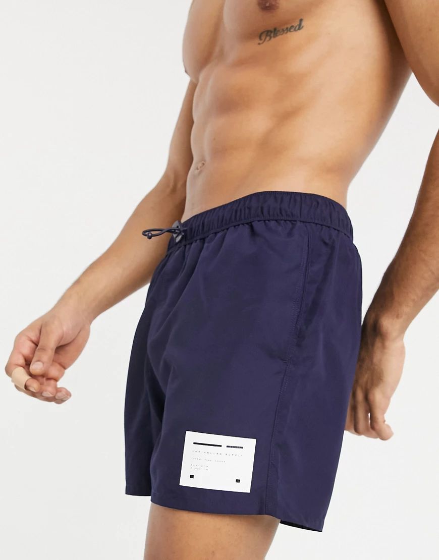 ASOS Unrvlld Supply swim short in navy with branded woven patch short length-Black | ASOS (Global)