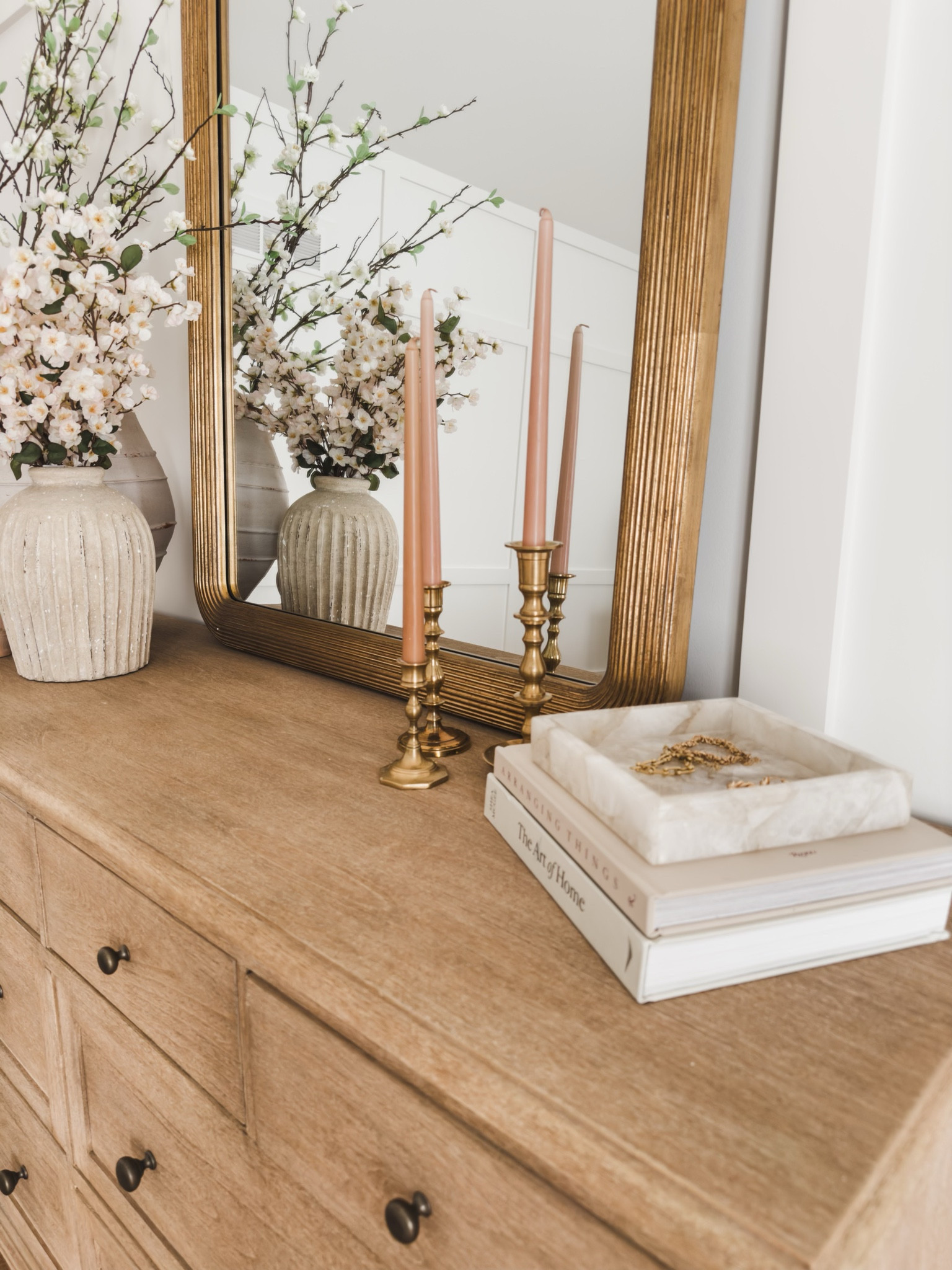 Bedroom details featuring pops of pink, blooming faux florals, neutral wood tones. The soft gold detail of this mirror ties in perfectly with these spring details 

Bedroom refresh, dresser details, furniture favorites, wooden furniture, pops of pink, neutral wood tones, gold detail, faux florals, spring refresh, vase favorites, mirror details, decor books, candlestick, tapered candle, Pottery Barn style, marble tray, found it on Amazon, Walmart, aesthetic home, neutral decor, shop the look!

#LTKstyletip #LTKSeasonal #LTKhome