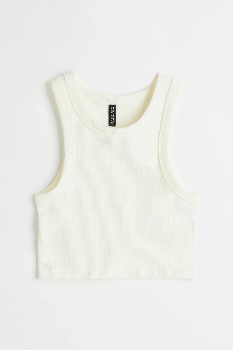 Short, fitted tank top in ribbed jersey. Narrow cut at top with a round neckline.SizeThe model is... | H&M (US + CA)