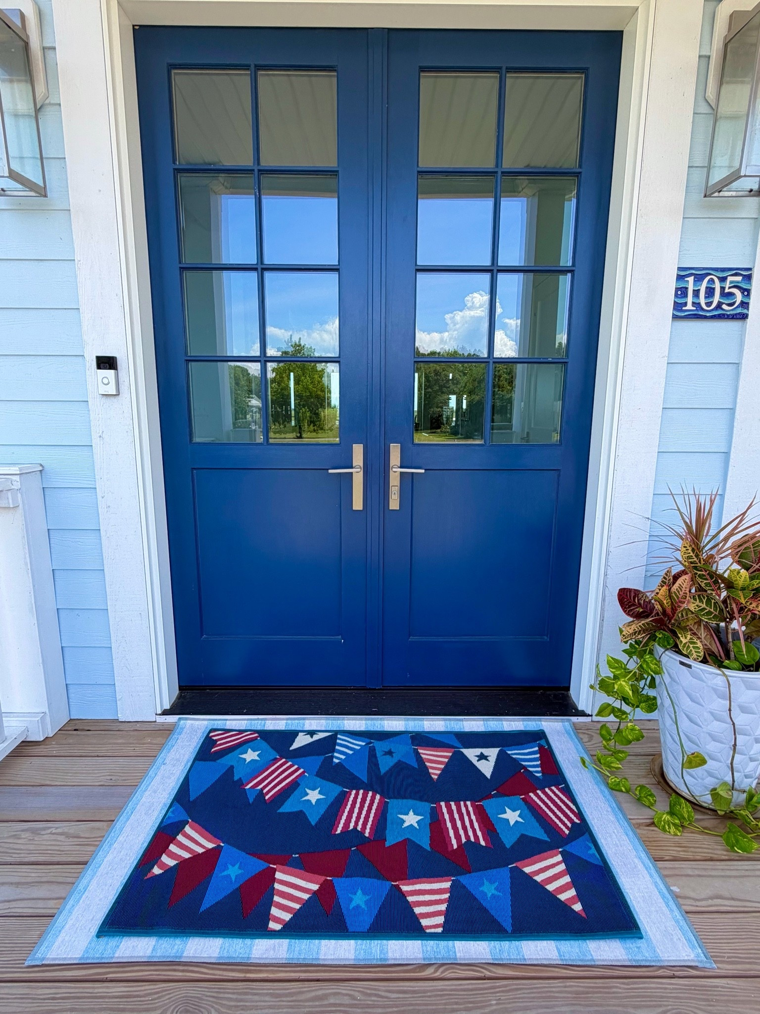 The perfect layering combination. The bottom light blue stripe matches the house color and the Americana flag mat ties the color of the doors in.

#LTKHome #LTKSeasonal