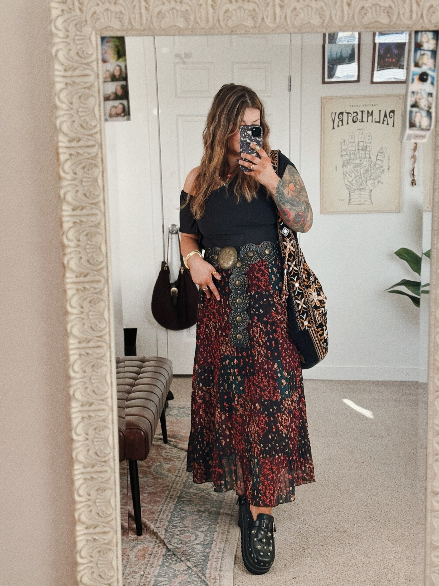 A whimsical alt mom outfit that feels like it belongs in a moody autumn fairytale. A soft black off shoulder top pairs beautifully with a flowing patchwork floral midi skirt in deep earthy reds and blacks, creating that romantic boho meets elder emo vibe. The oversized vintage coin belt adds a magical, slightly witchy touch while chunky black platform clogs keep the look grounded and effortlessly cool. Finished with a woven boho bag and layered jewelry, this outfit feels like wandering through a cozy antique shop, writing poetry in a candlelit café, or stepping into a slightly mysterious storybook world.

#LTKMidsize #LTKPlusSize