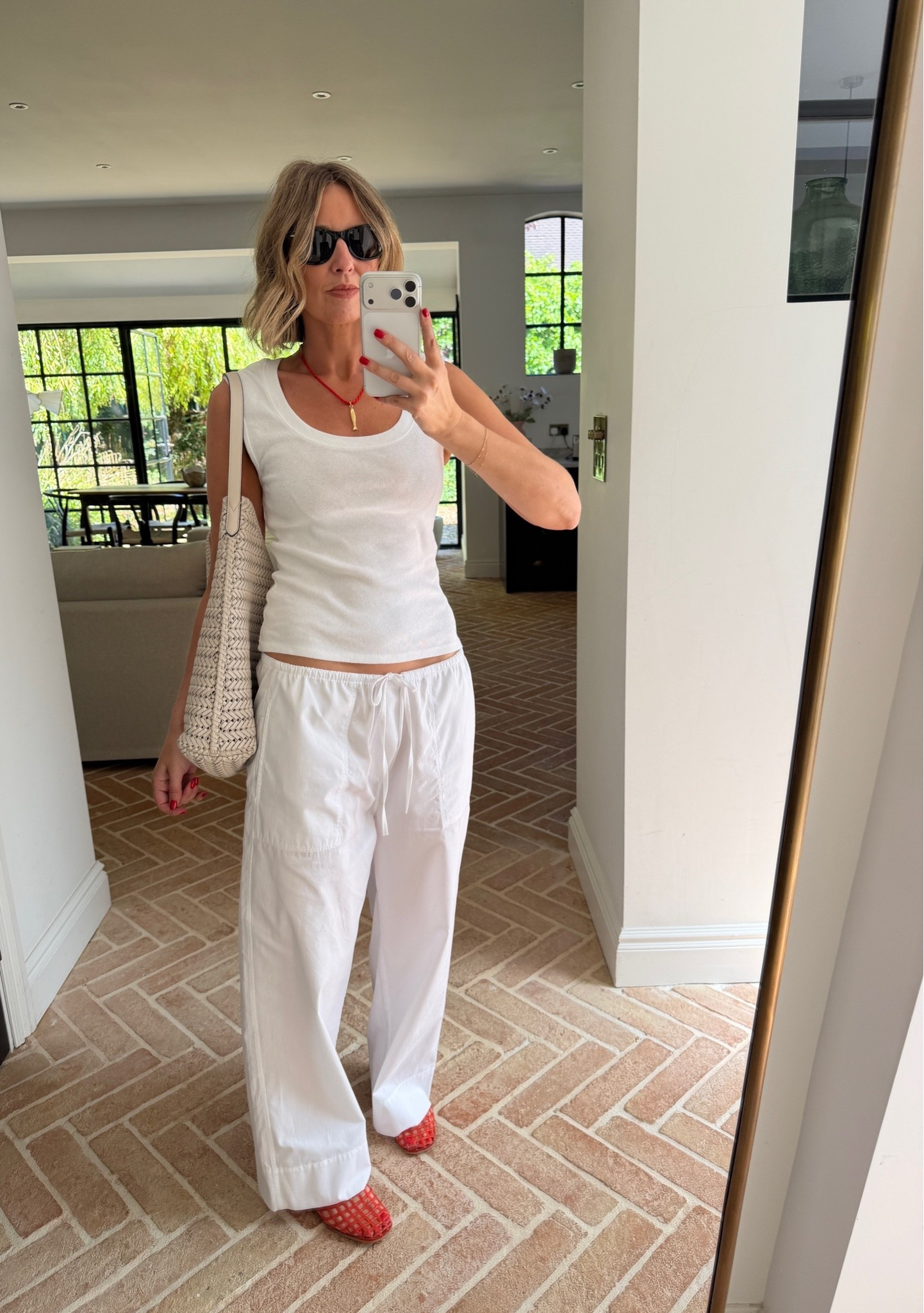 white tank top, ribbed tank, scoop neck tank, white cargo trousers, wide leg linen pants, drawstring waist trousers, red woven mules, red slide sandals, woven straw tote, cream woven bag, gold necklace, red pendant necklace, black cat eye sunglasses, all white outfit, summer casual style, effortless summer style, elevated basics, quiet luxury, neutral color palette, pop of color styling, mirror selfie ootd, ltkstyletip, ltkseasonal, ltksummer, ltkfindsunder100, ltkbeauty, ltkitbag

#LTKsummer #LTKworkwear #LTKtravel