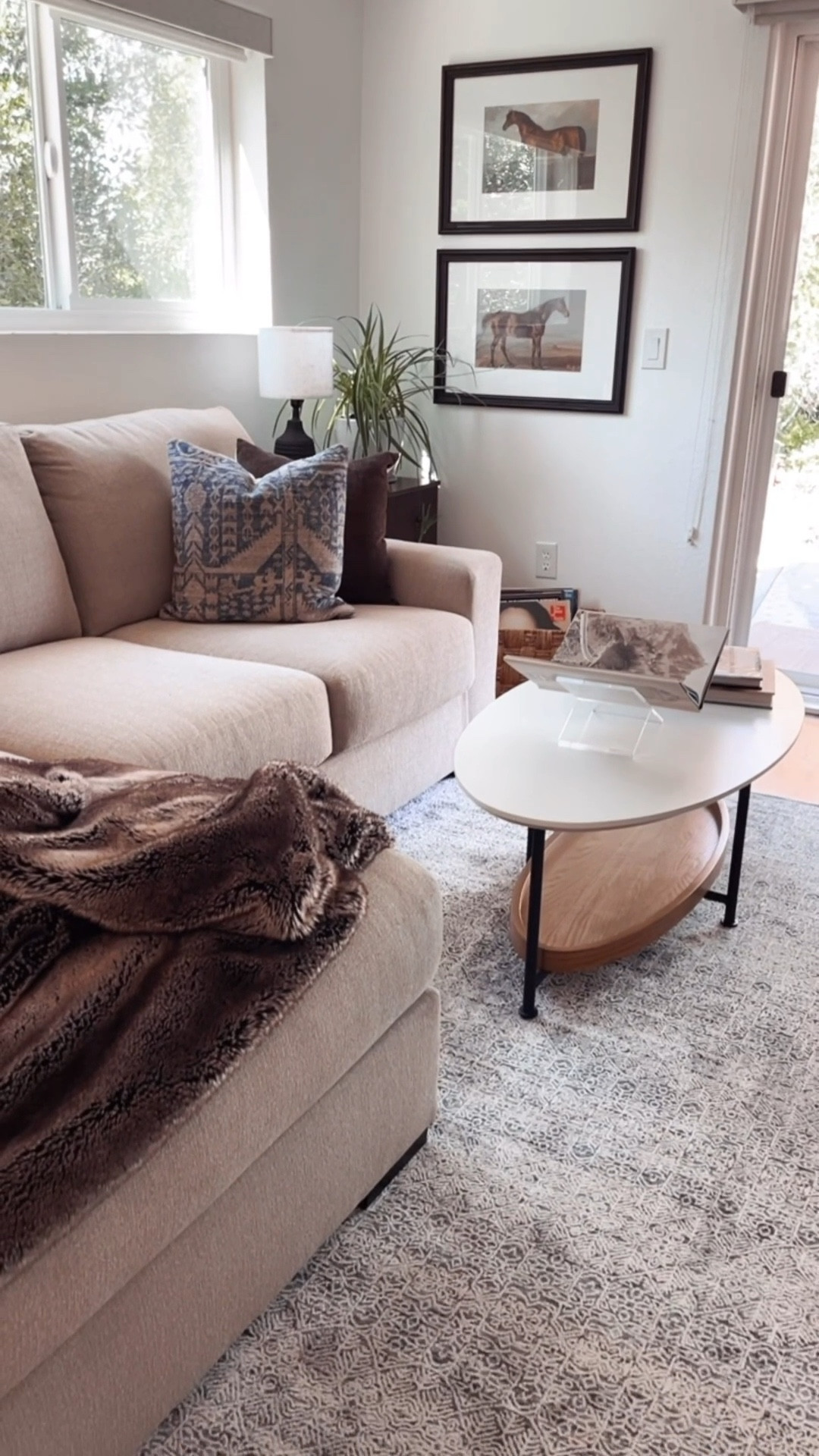Small apartment living room with sectional/chaise and denim blue area rug. Small oval coffee table with shelf on bottom. Equestrian art prints on the wall. 

#LTKSaleAlert #LTKHome