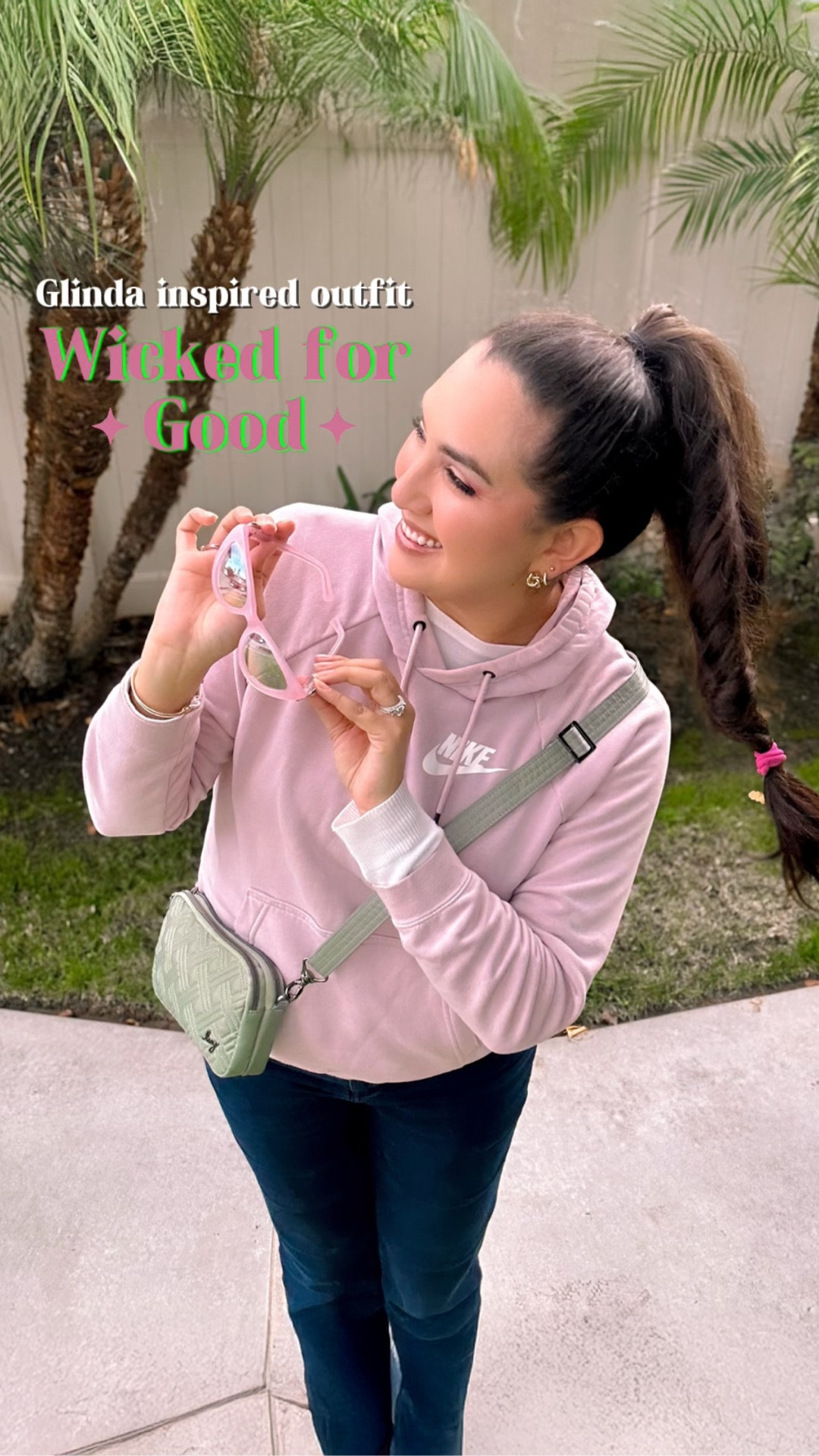 🩷💚 A subtle pink-and-green outfit today as we all prepare for Wicked: For Good this week 🥰  It’s comfy, casual, and cute! 

Glinda herself might be more of a glam girly, but this outfit is still charming. It’s a light pink Nike hoodie, with matching pink Nike shoes, pink Glinda sunglasses and a sage green purse 😊

✨ It's something you could wear to the movie coming out this week or even to Universal Studios for a theme park day out. 🤗

If you're looking for something a little more glamorous, check out my other Wicked For Good inspired outfits to prepare for this week's movie premiere 🫶🏼🎥🎞️👗

💁🏻‍♀️Let me know in the comments, are you Glinda or more Elphaba?

Wicked For Good, Wicked outfit, Wicked OOTD, Angie's Magical Style, Glinda style, Elphaba Style, Wicked Style, Universal Pictures Wicked For Good, pink outfit, lug life, gold jewelry, fandom fashion sunglasses, pink makeup glam 

#LTKBeauty #LTKdayinmylife #LTKootd