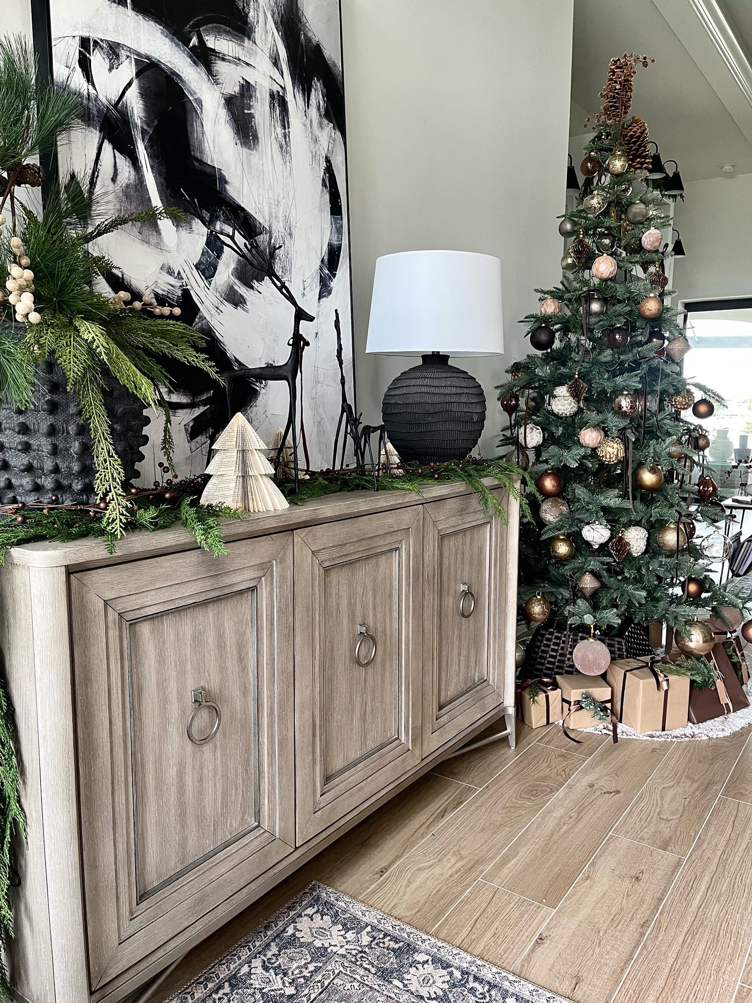 Entryway Decor
Console table  black and white art, Christmas trees, potterybarn deer, black table lamp  anthropologie vase, garland, greenery #wayfair, anthropologie 

#LTKhome #LTKSeasonal #LTKHoliday