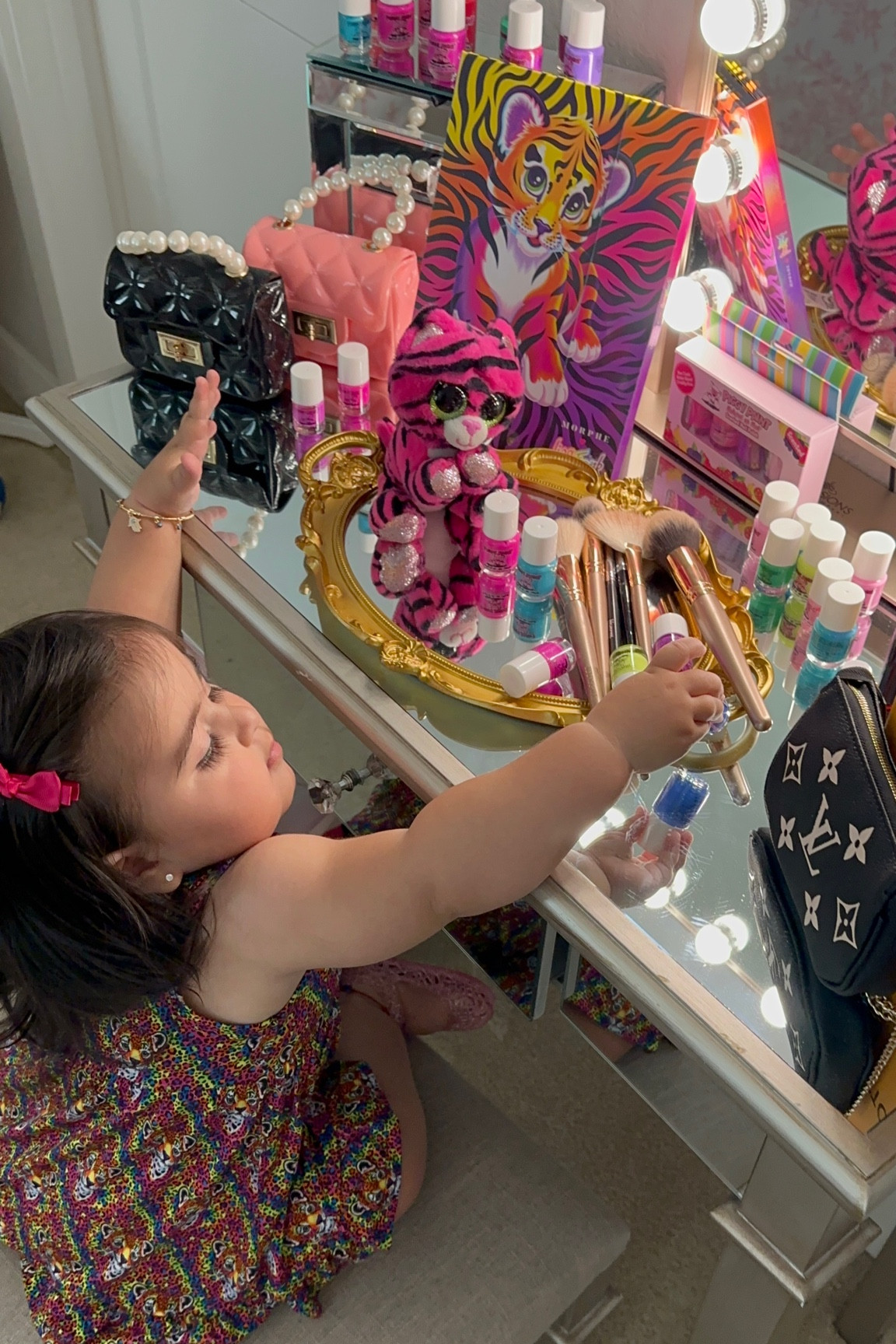 Little fashionista looking fab in her Lisa frank x posh peanut collab dress. Admiring her piggy paint nail polish collection that’s non toxic and safe for babies. 🐆🌈💅🏼👛🧿🐅