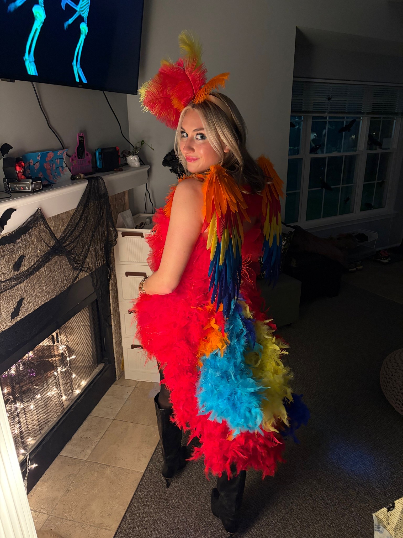 DIY Parrot costume!! After many hours of sewing and working with jewelry wire, I successfully pulled off the best costume ever. 

I started with some amazing basic feather boas, a headband, and feather packs. I sewed and got glued feathers onto the headband, and used 16 gauge jewelry wire to make the tail. The get the tail on me, I made a belt of 14 gauge wire and tied it around my waist with  twist tie. 

 The wings were luckily easy to buy pre-made, so I can’t take credit for those! 

For the dress, I bought something that already had a pattern on the front. The back came blank, so I hand made and sewed each tulle and feather decal onto the dress. 

I paired it with my black sheertex because the parrots have black legs, and some boots to keep feet warm!