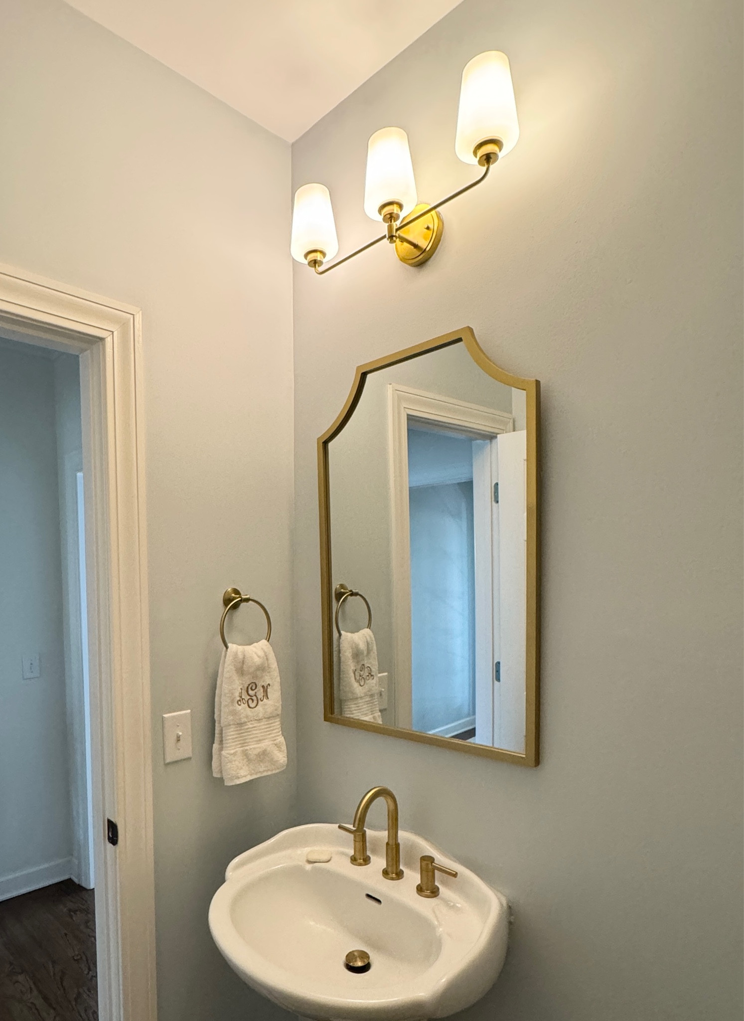 Brushed gold bathroom faucet sink. Mirror. Light fixture. 